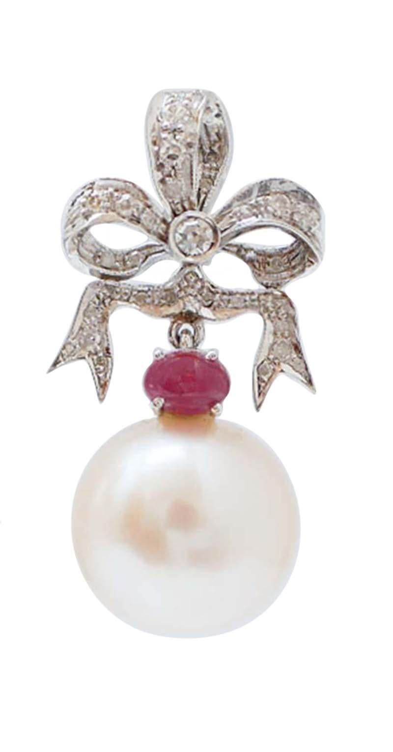 Boucles d'oreilles pendantes en structure d'or blanc 14 kt montées avec des diamants et des rubis ;  comme pendentif, une perle blanche.
Ces boucles d'oreilles ont été entièrement réalisées à la main par des maîtres orfèvres italiens et elles sont