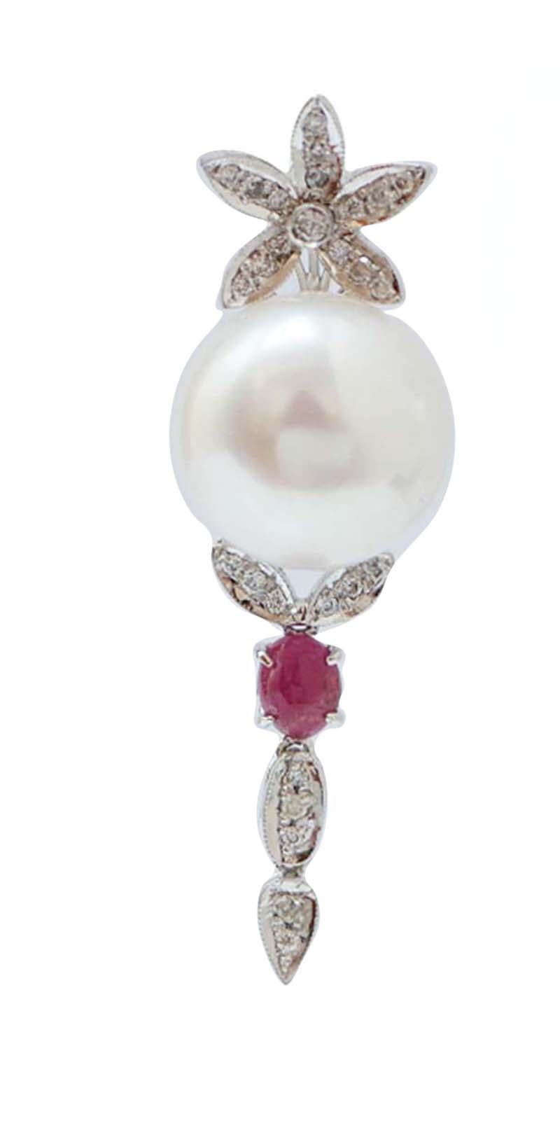 Fantastiques boucles d'oreilles en structure de platine montées avec une fleur de diamants dans la partie supérieure ; au milieu, une perle blanche et, en dessous, des feuilles constellées de diamants et, entre elles, un rubis.
Ces boucles