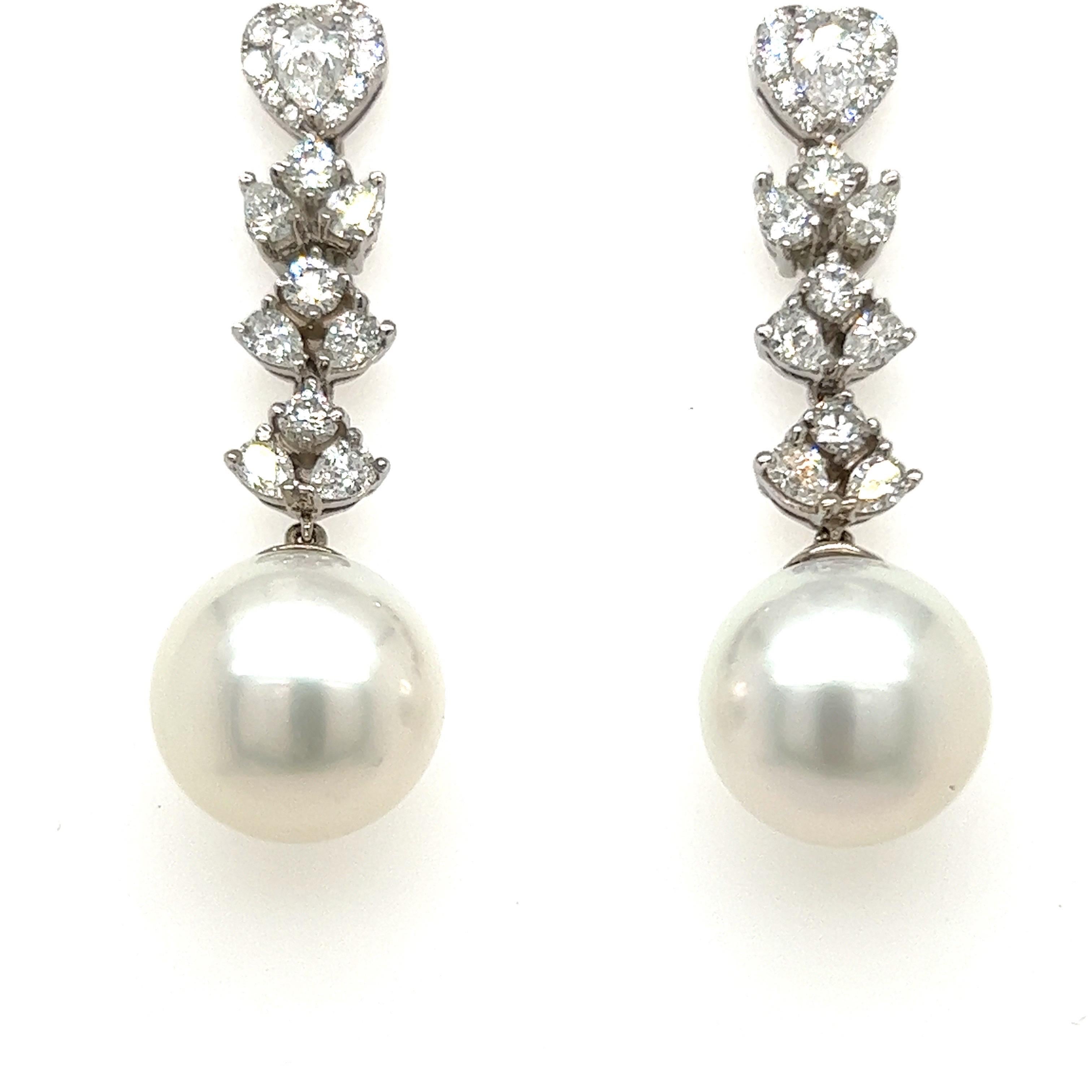 Glamorous South Sea Pearl earrings. High pearly luster,  
silver overtone, 13mm natural South Sea matching pearls, accented with pear shape and round  brilliant cut diamonds. Handcrafted design set in 18 karats white gold with post and butterfly