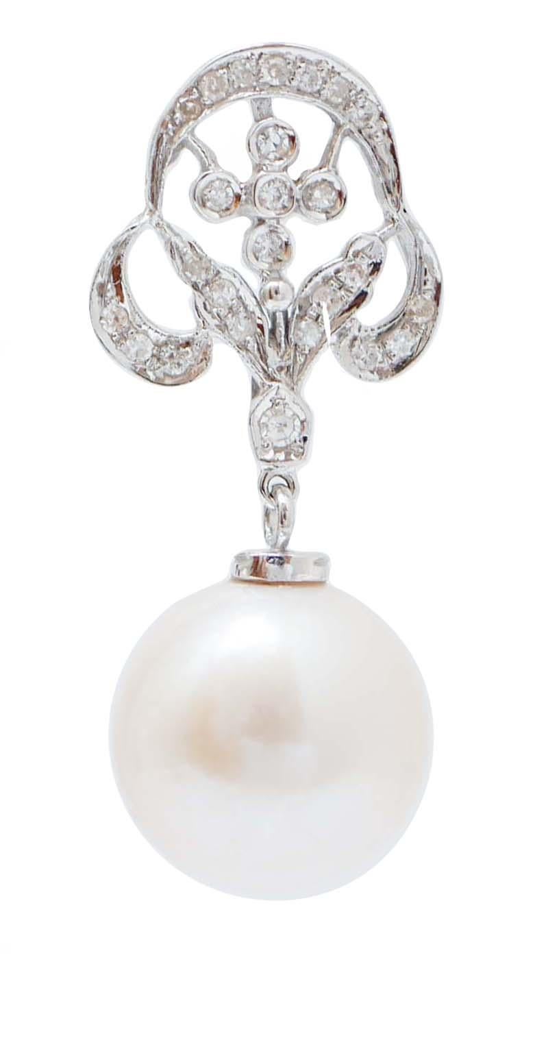 Belles boucles d'oreilles en structure d'or blanc 14 kt montées avec des diamants et, en pendentif, une perle.
Ces boucles d'oreilles ont été entièrement réalisées à la main par des maîtres orfèvres italiens et elles sont en parfait état.
Diamants