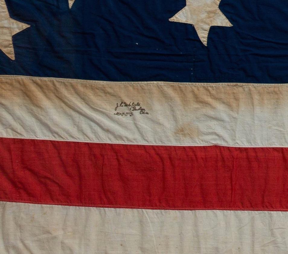Presented is a bright 13-star handcut American Flag, signed by J.L. Wakefield from Preston, Ohio and dated November 10, 1884. This flag's canton features the highly sought-after medallion star pattern, with one large central star, encircled by a