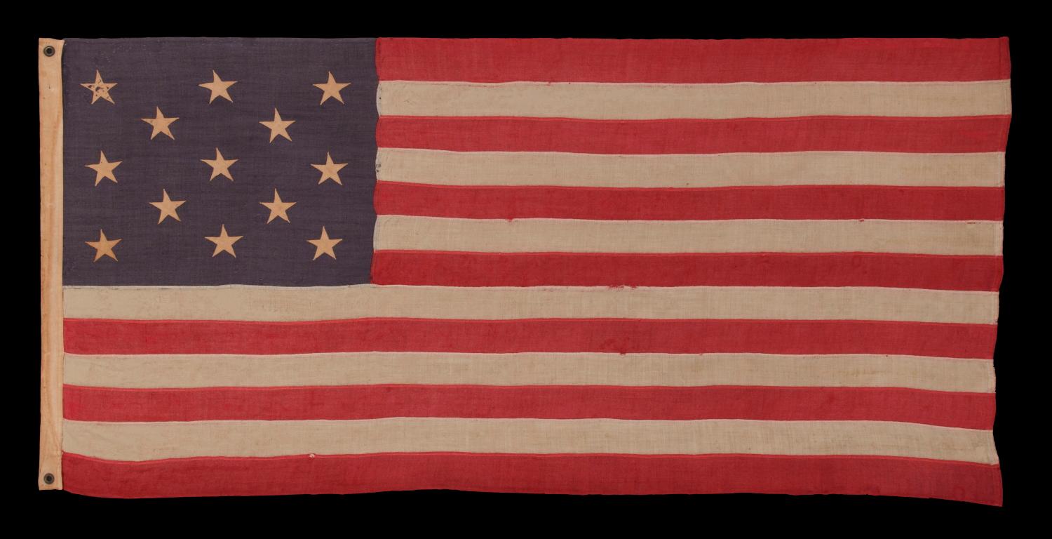 13 stars in a 3-2-3-2-3 pattern on a dusty blue canton, on a small-scale, antique American flag with an elongated profile, made during the last decade of the 19th century, circa 1890-1895:

This 13 star antique American flag is of a type made