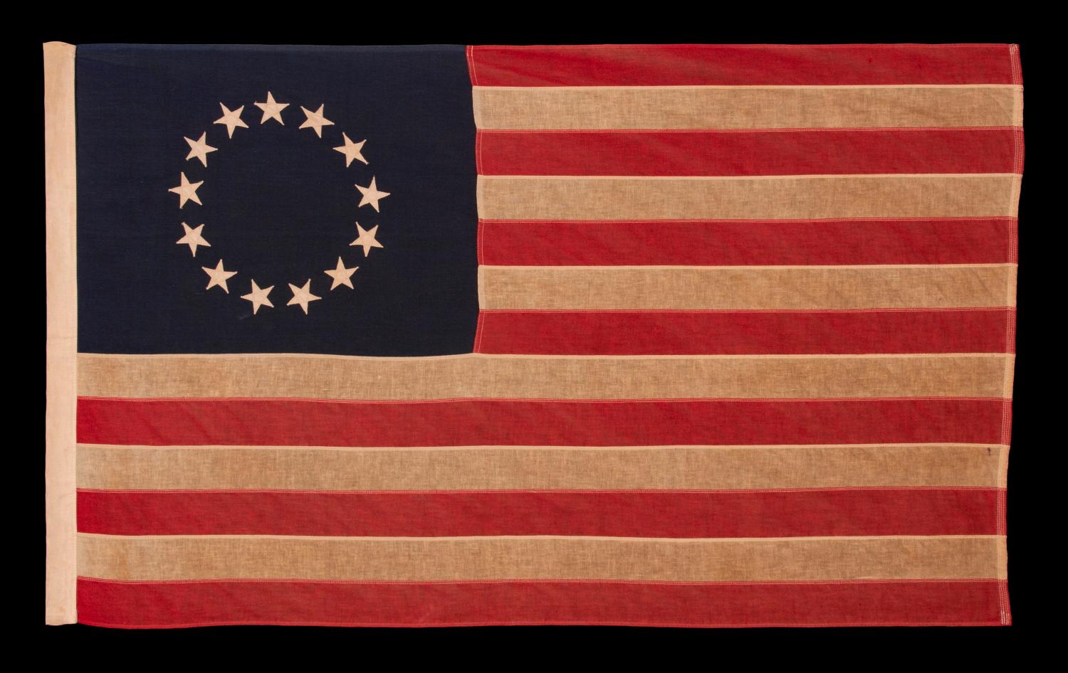 13 STARS IN THE BETSY ROSS PATTERN, A SCARCE SEWN EXAMPLE IN A DESIRABLE SMALL SCALE, 1900-1930 

13 star American national flag, made in the period between approximately 1900 and 1930. The stars are arranged in the circular wreath pattern most