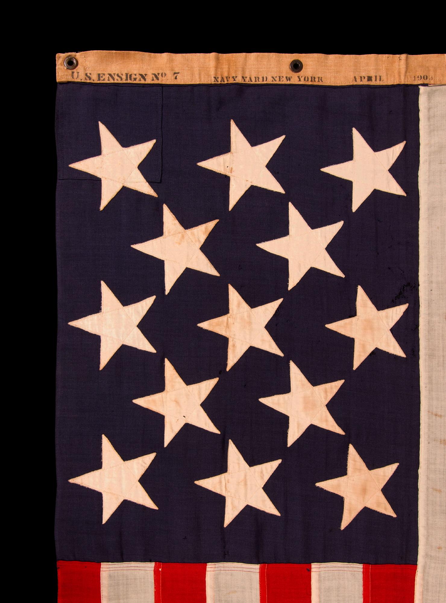 13 STAR ANTIQUE AMERICAN FLAG w/ A 3-2-3-2-3 PATTERN OF ESPECIALLY LARGE STARS; A U.S. NAVY SMALL BOAT ENSIGN, SIGNED & DATED 1903, MADE AT THE BROOKLYN NAVY YARD IN NEW YORK CITY

13 star American national flag of the type used by the U.S. Navy on
