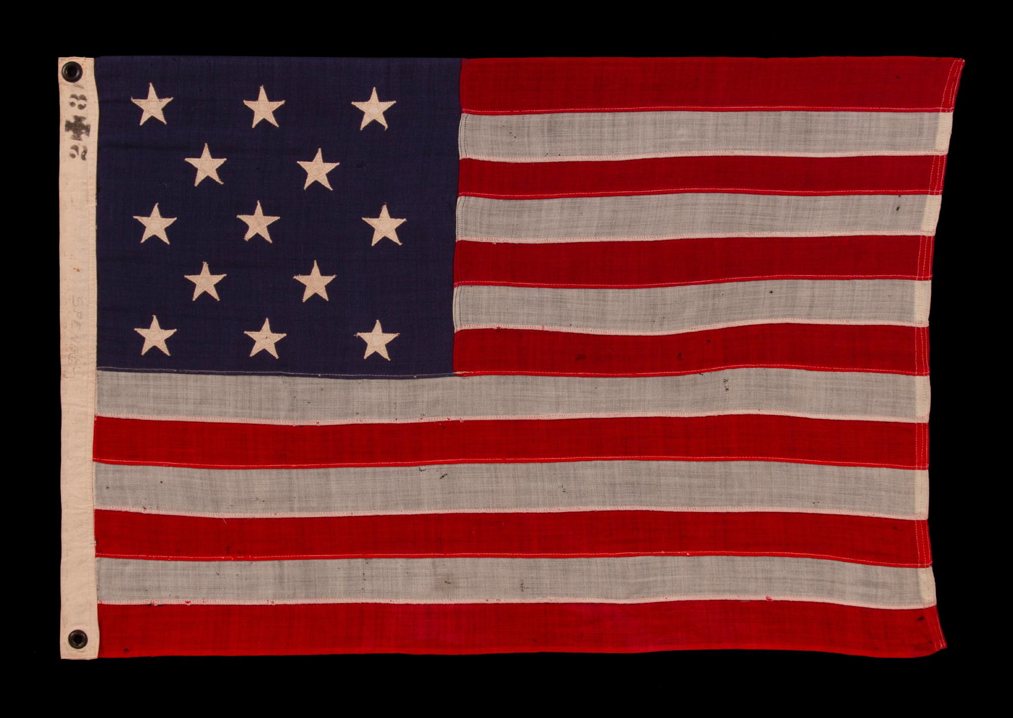 13 STAR ANTIQUE AMERICAN FLAG WITH A 3-2-3-2-3 CONFIGURATION OF STARS ON AN ATTRACTIVE, INDIGO BLUE CANTON ; A SMALL-SCALE EXAMPLE OF THE 1895-1926 ERA, INSCRIBED WITH THE SURNAME 