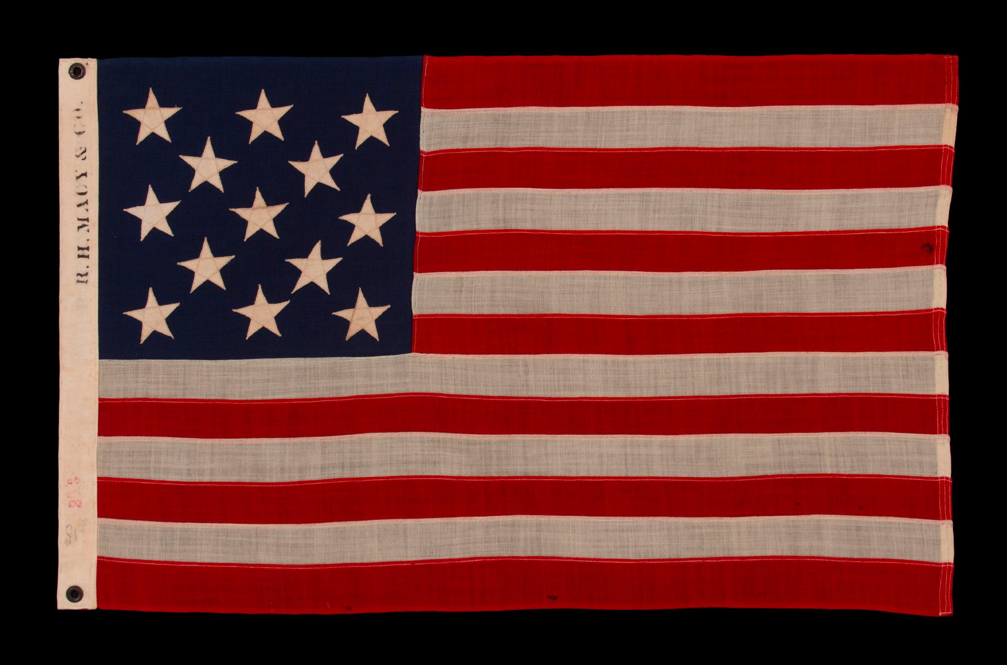 13 STAR ANTIQUE AMERICAN FLAG WITH A 3-2-3-2-3 CONFIGURATION OF STARS; A SMALL-SCALE EXAMPLE, MADE IN THE 1895-1926 ERA, MARKED “R.H. MACY & CO.”

13 star antique American flag of the small-scale type made during the last decade of the 19th century