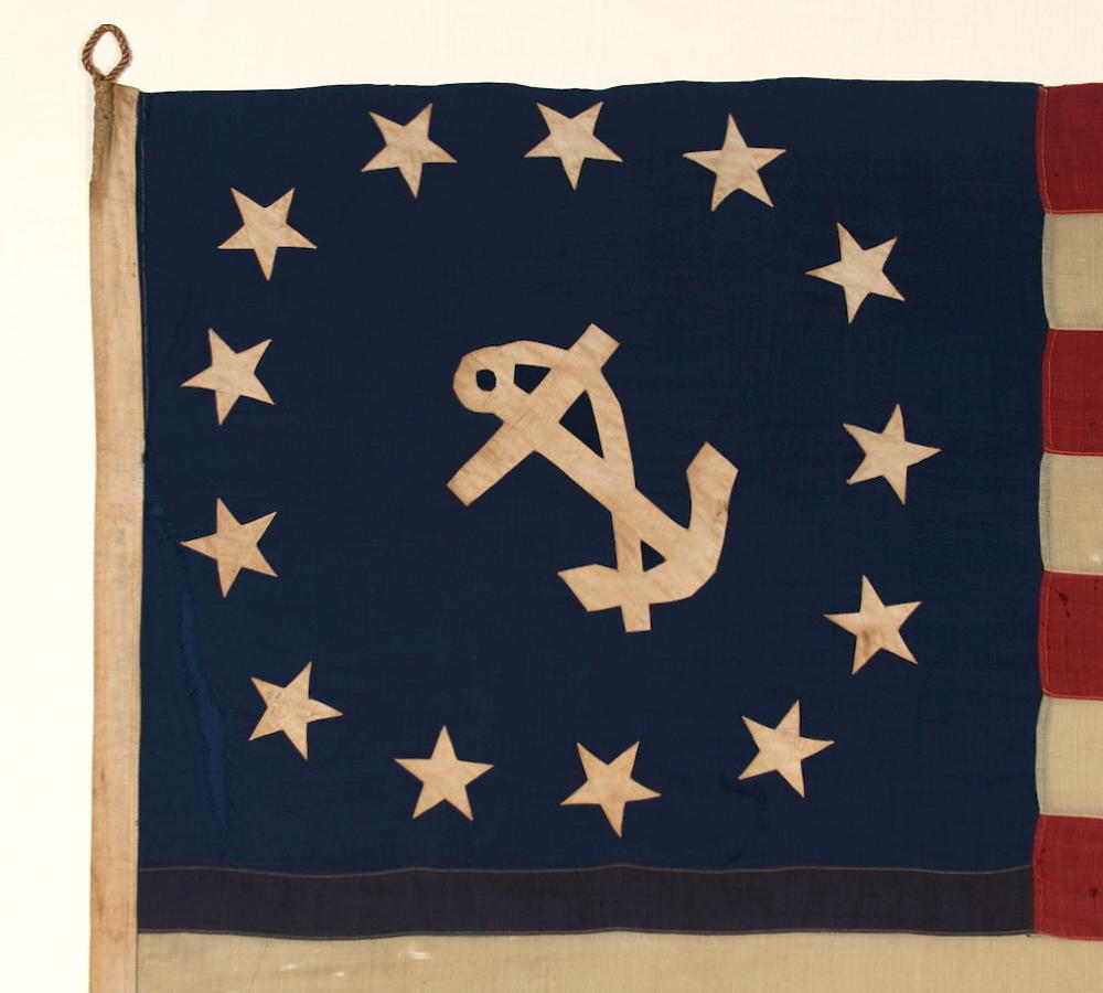 ANTIQUE AMERICAN PRIVATE YACHT FLAG (ENSIGN) WITH 13 STARS AROUND A CANTED ANCHOR, IN A VERY LARGE SCALE FOR THE FORM, MADE DURING THE LAST DECADE OF THE 19TH CENTURY:

The medallion configuration, 13-star, 13-stripe flag with a canted center anchor