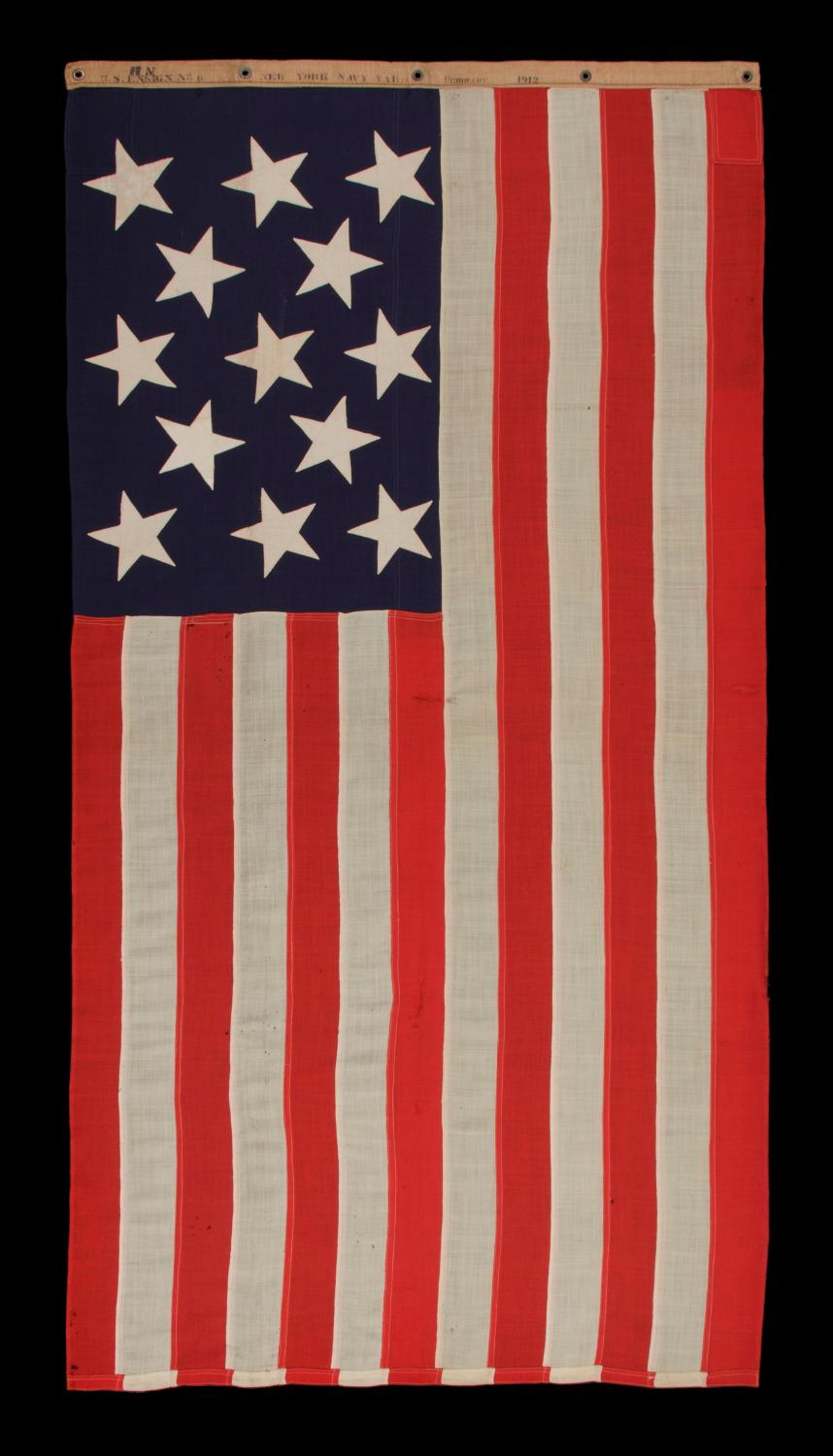 13 STARS IN A 3-2-3-2-3 PATTERN ON AN ANTIQUE AMERICAN FLAG, A UNITED STATES NAVY SMALL BOAT ENSIGN, MADE AT THE BROOKLYN NAVY YARD, NEW YORK, SIGNED & DATED 1912 

13 star American national flag of the type used by the U.S. Navy on small boats