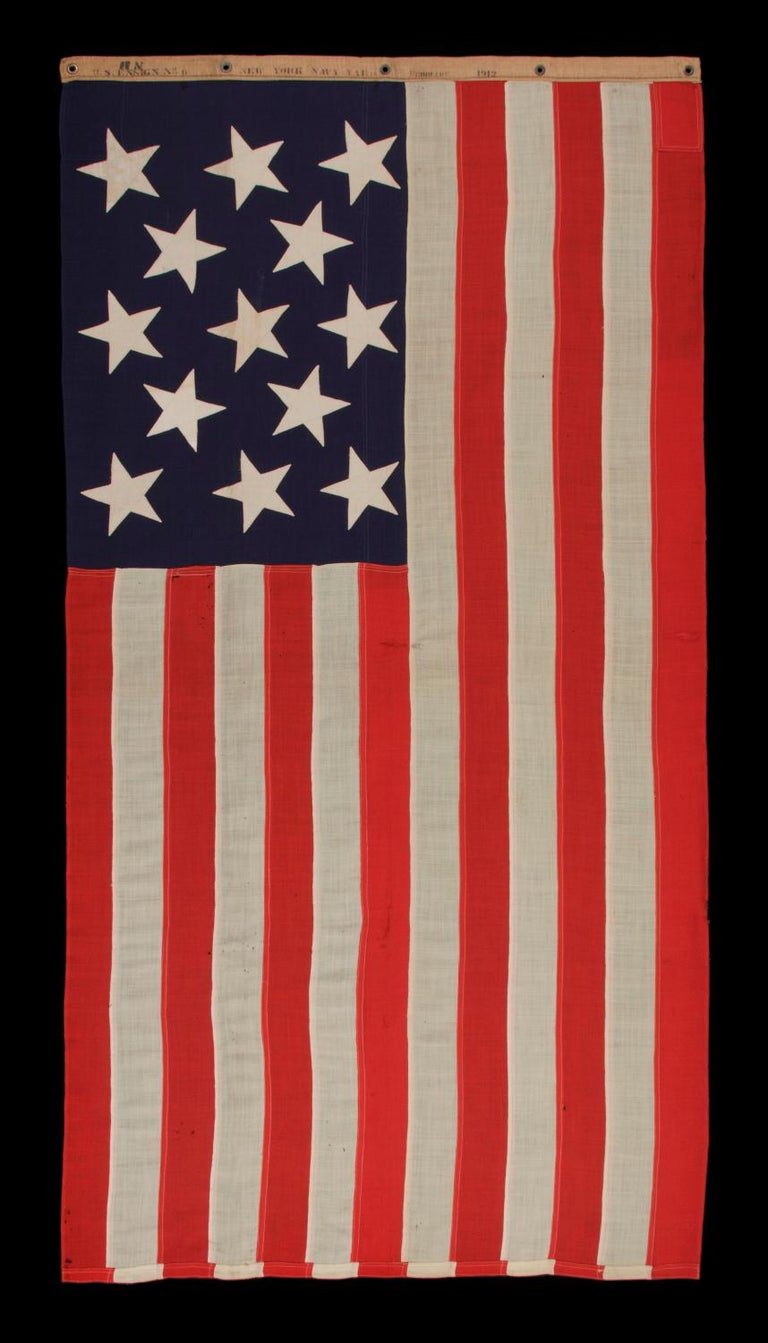 13 STARS IN A 3-2-3-2-3 PATTERN ON AN ANTIQUE AMERICAN FLAG, A UNITED STATES NAVY SMALL BOAT ENSIGN, MADE AT THE BROOKLYN NAVY YARD, NEW YORK, SIGNED & DATED 1912 

13 star American national flag of the type used by the U.S. Navy on small boats