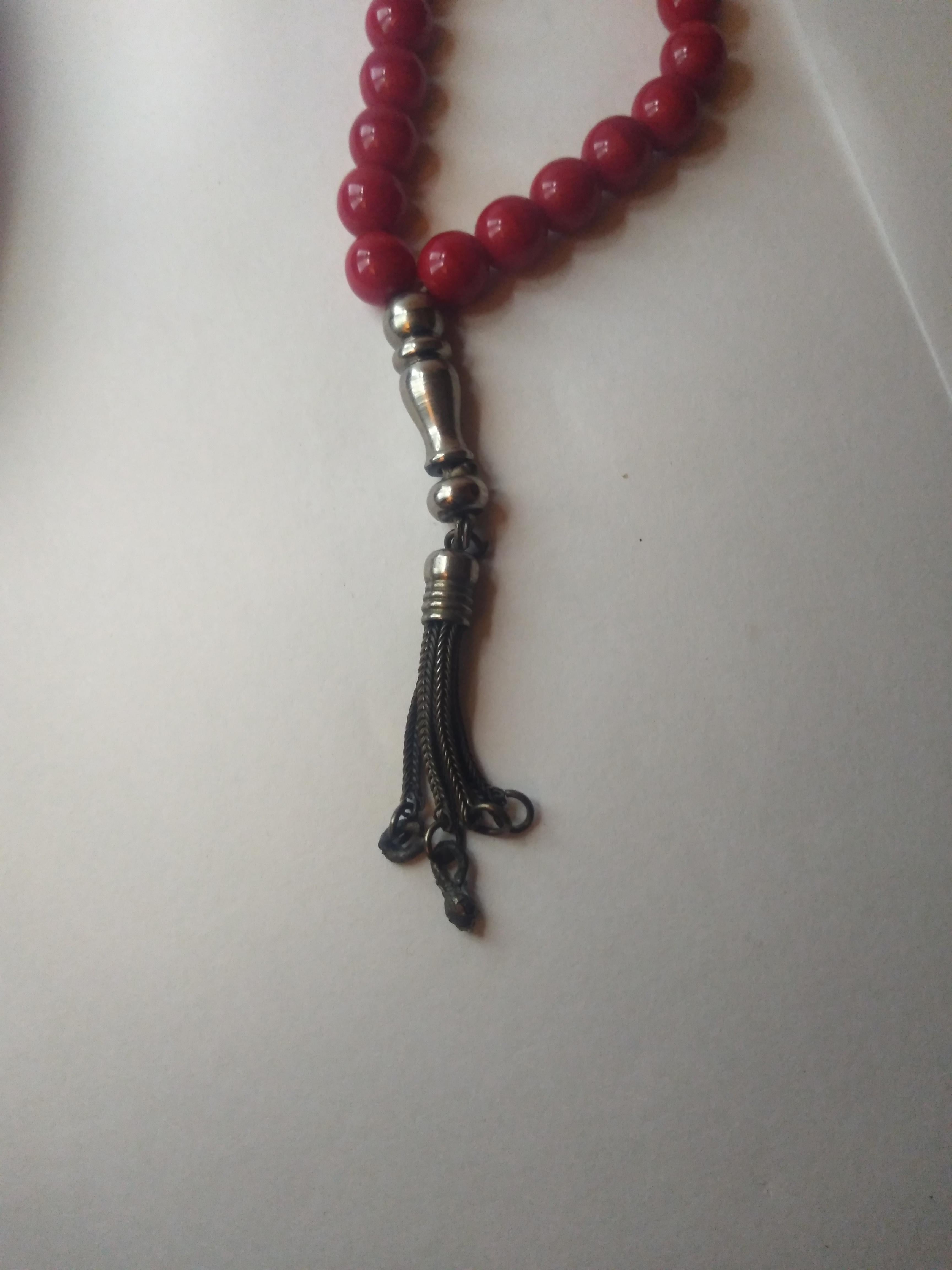 These are worry beads. The beads are red and the metal work is sterling silver. 