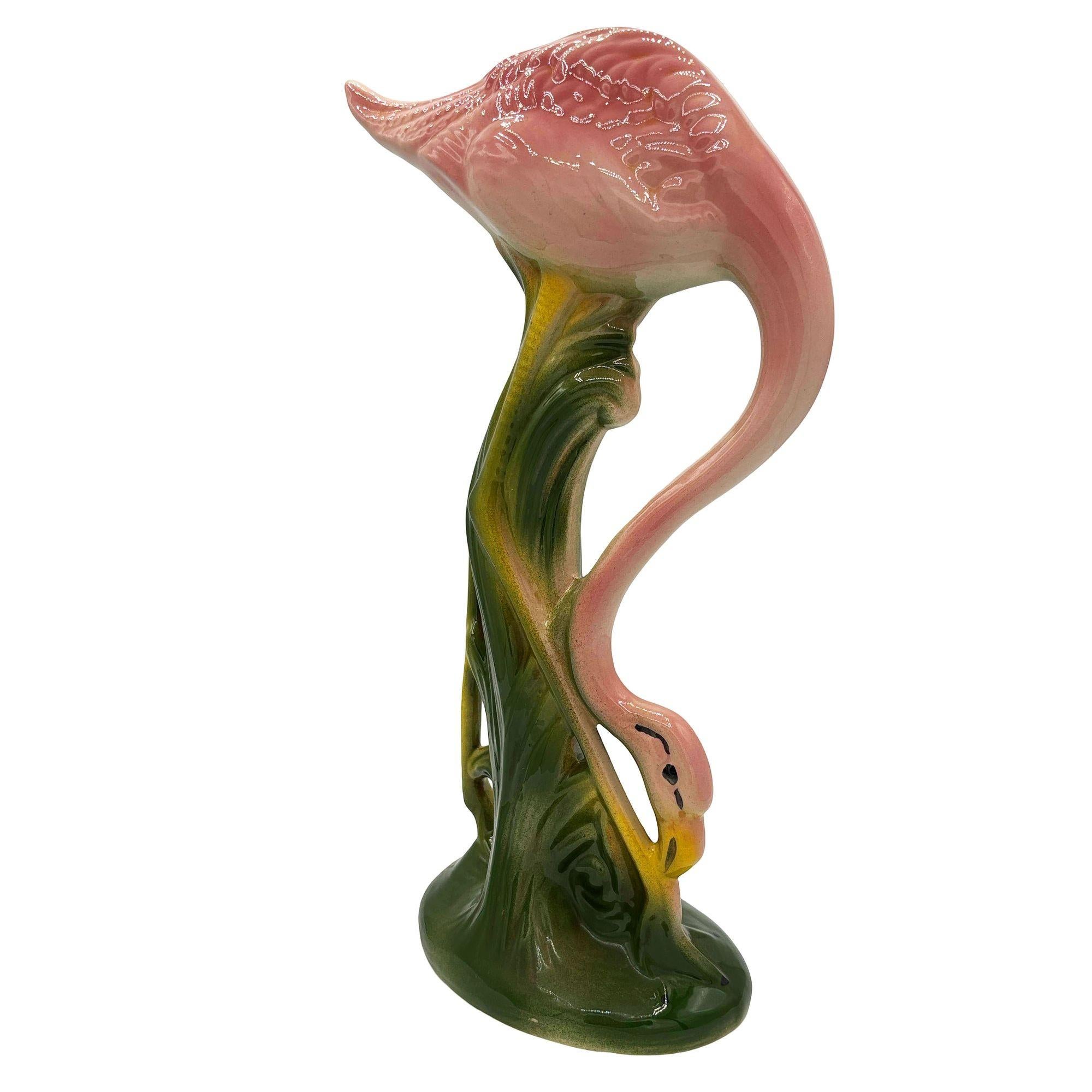 Statuetta in ceramica di fenicottero a zampe lunghe rosa e verde di metà secolo. La statua raffigurava un fenicottero rosa dalle lunghe zampe, una forma snella e alta che si ergeva su un campo erboso. La finitura lucida mette in risalto i ricchi