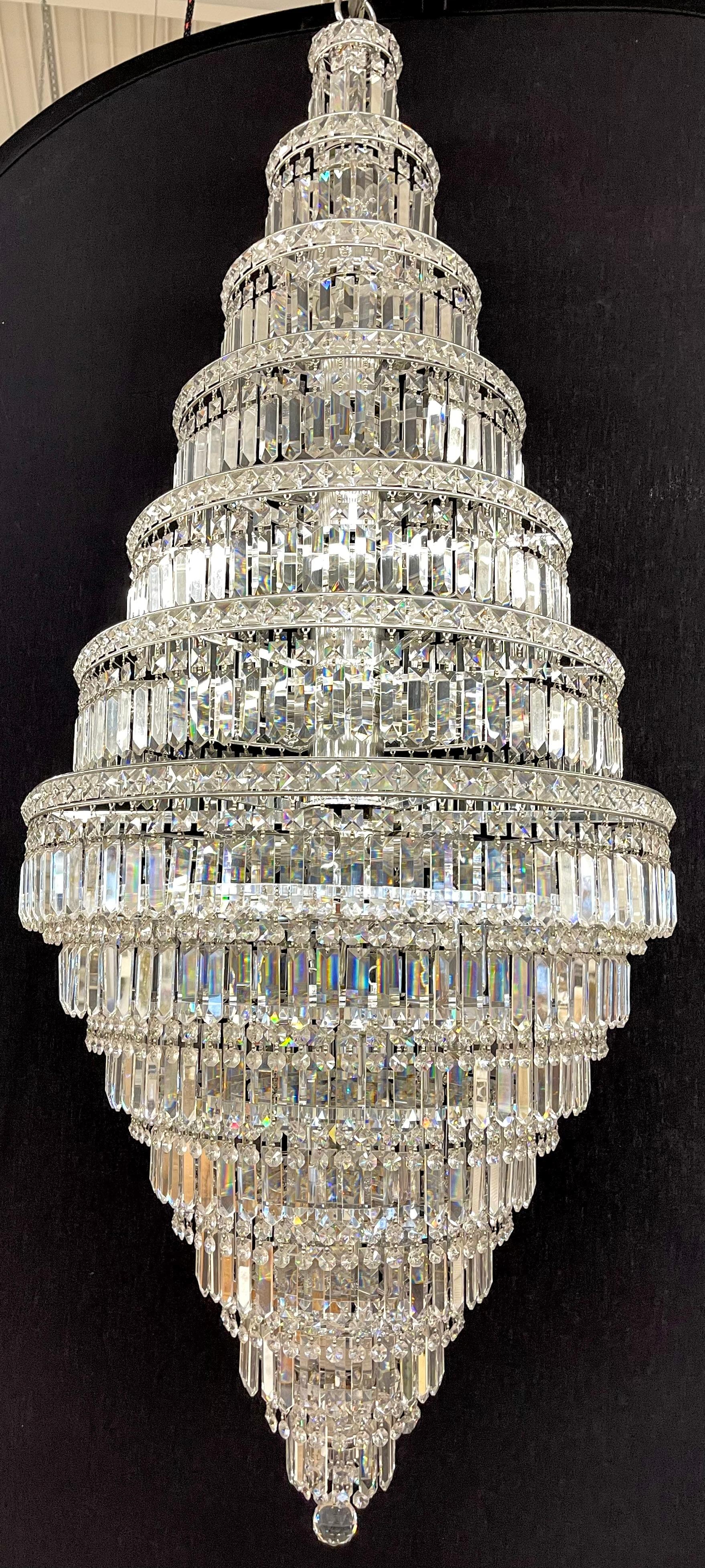 A wedding cake chandelier circa 1970s from a Greenwich CT estate. This 34 bulb (40 watt), 60 inch High by 24 inches at its widest point Chandelier has a myriad of 5 inch glass crystals on each tier. This is a stunning example of workmanship as it is