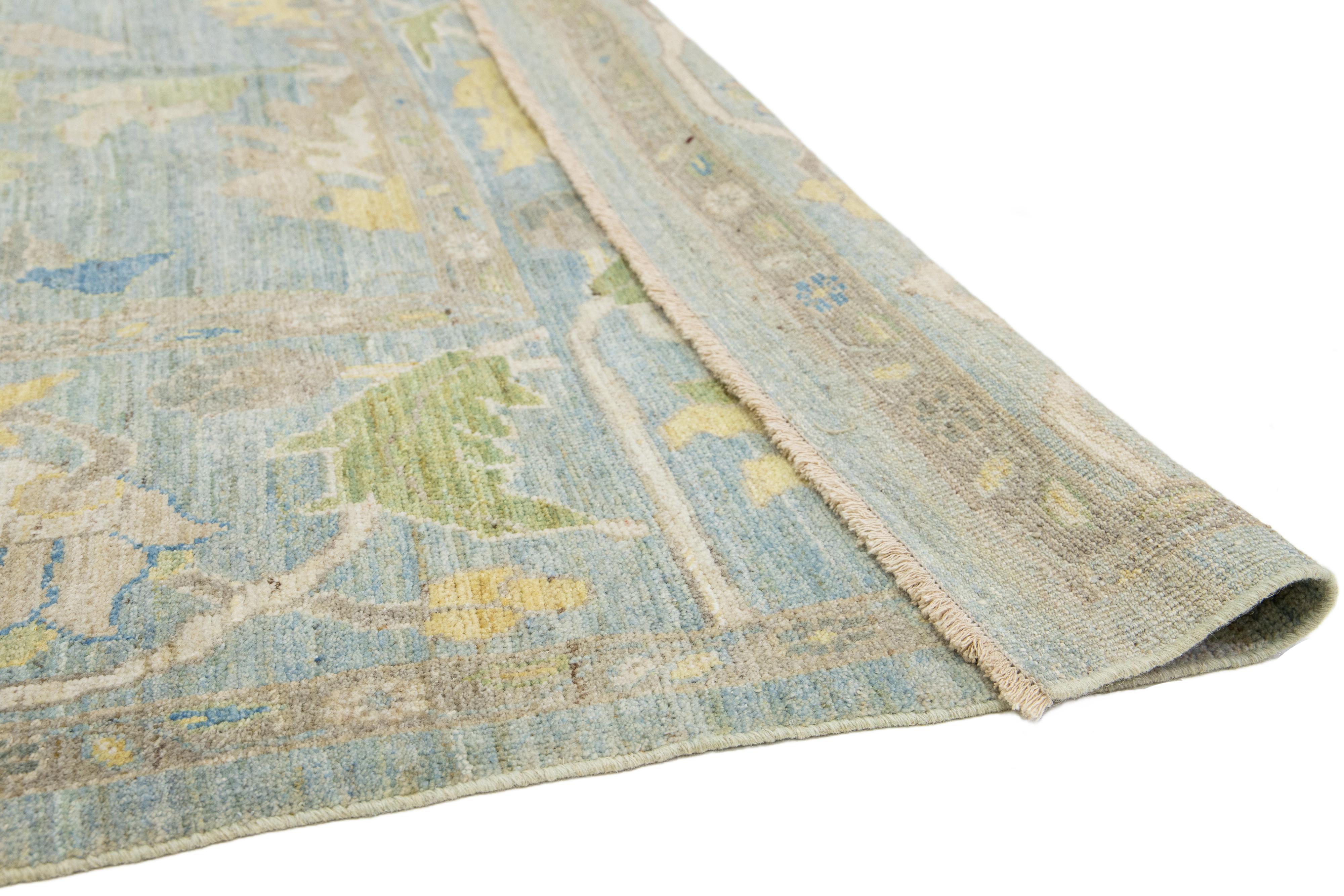 This hand-knotted Sultanabad wool rug has a light blue background with multicolored all-over designs.

This rug measures 12'6'' x  15'1