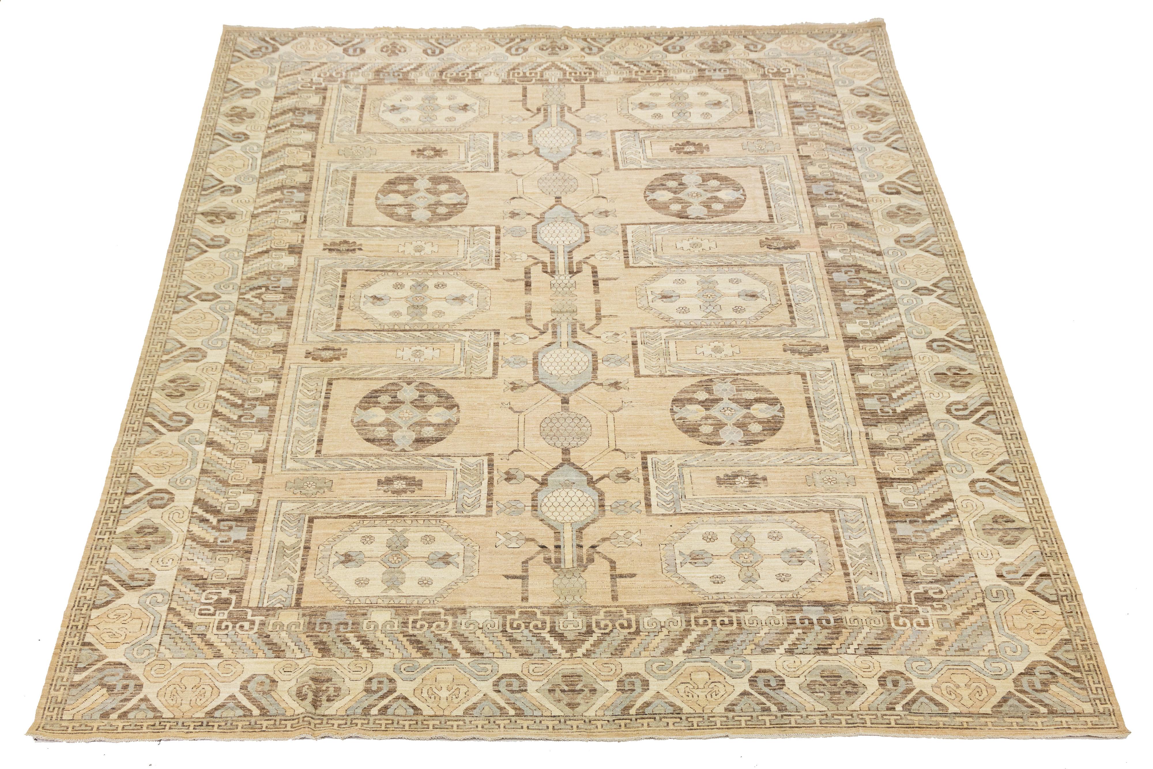 Ce tapis en laine noué à la main dans le style Khotan présente un champ beige et des accents bruns et bleus. Le design présente un motif all-over qui incorpore des éléments de style moderne.

Ce tapis mesure 13'2