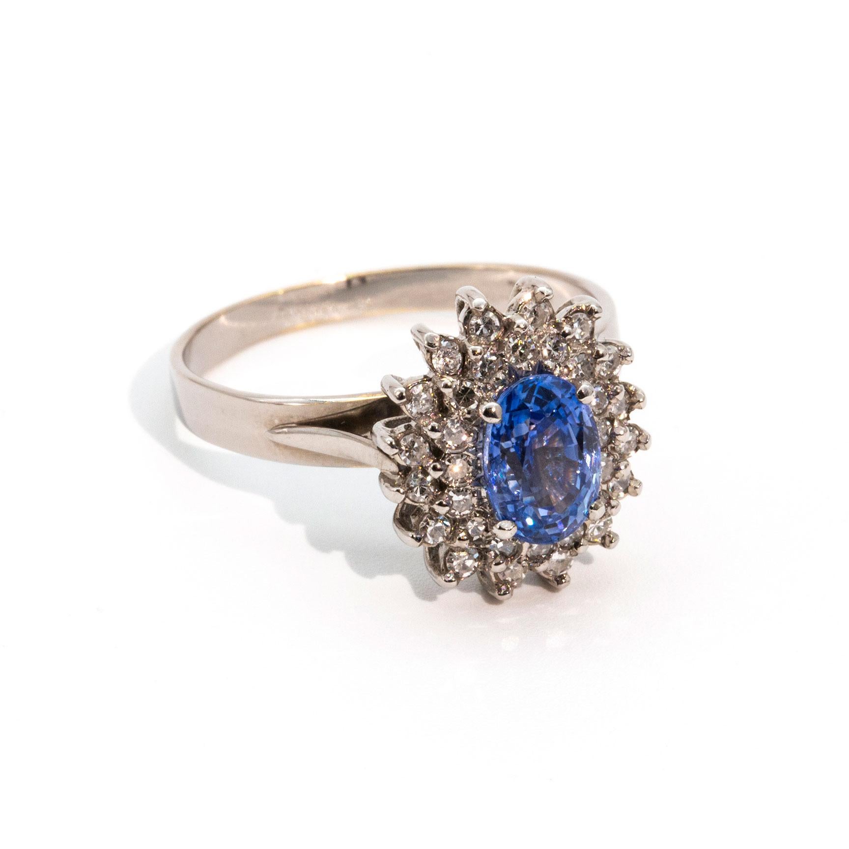 This timeless cluster ring is forged in 18 carat white gold and features a stunning 1.30 carat Ceylon sapphire and is surrounded by a double border of glimmering round diamonds. We named this beauty The Journee Ring.  The Journee Ring is a classic