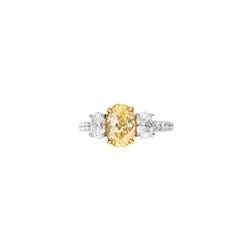 1.30 Carat Fancy Yellow Oval Diamond Three-Stone Engagement Ring, GIA Certified.