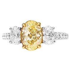 1.30 Carat Fancy Yellow Oval Diamond Three-Stone Engagement Ring, GIA Certified.