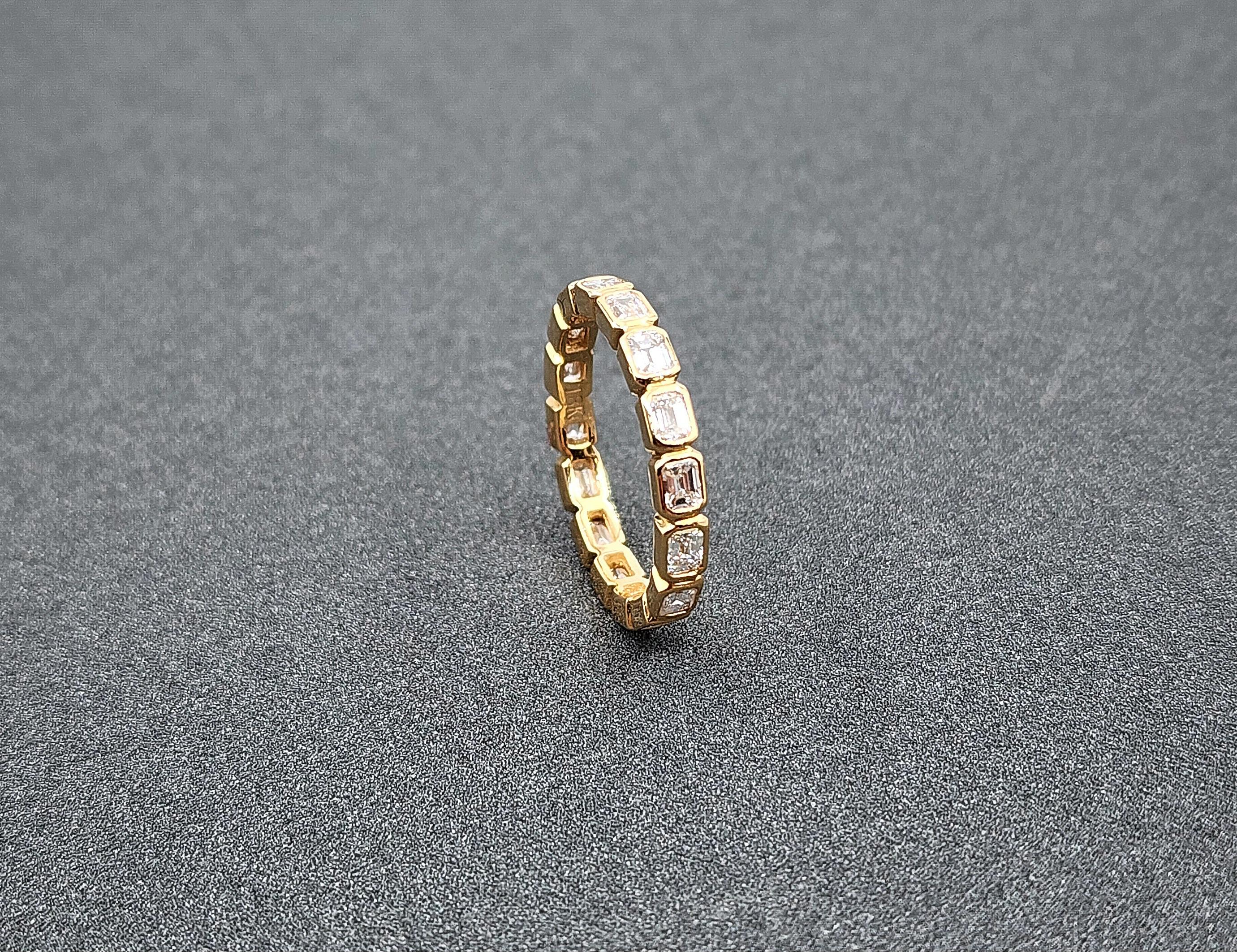 This gorgeous diamond eternity band features 16 emeralds bezel set in a lovely 18k yellow gold. The diamonds showcase E/F in color and VS1 in clarity. A stunning ring to add to any jeweler's collection.