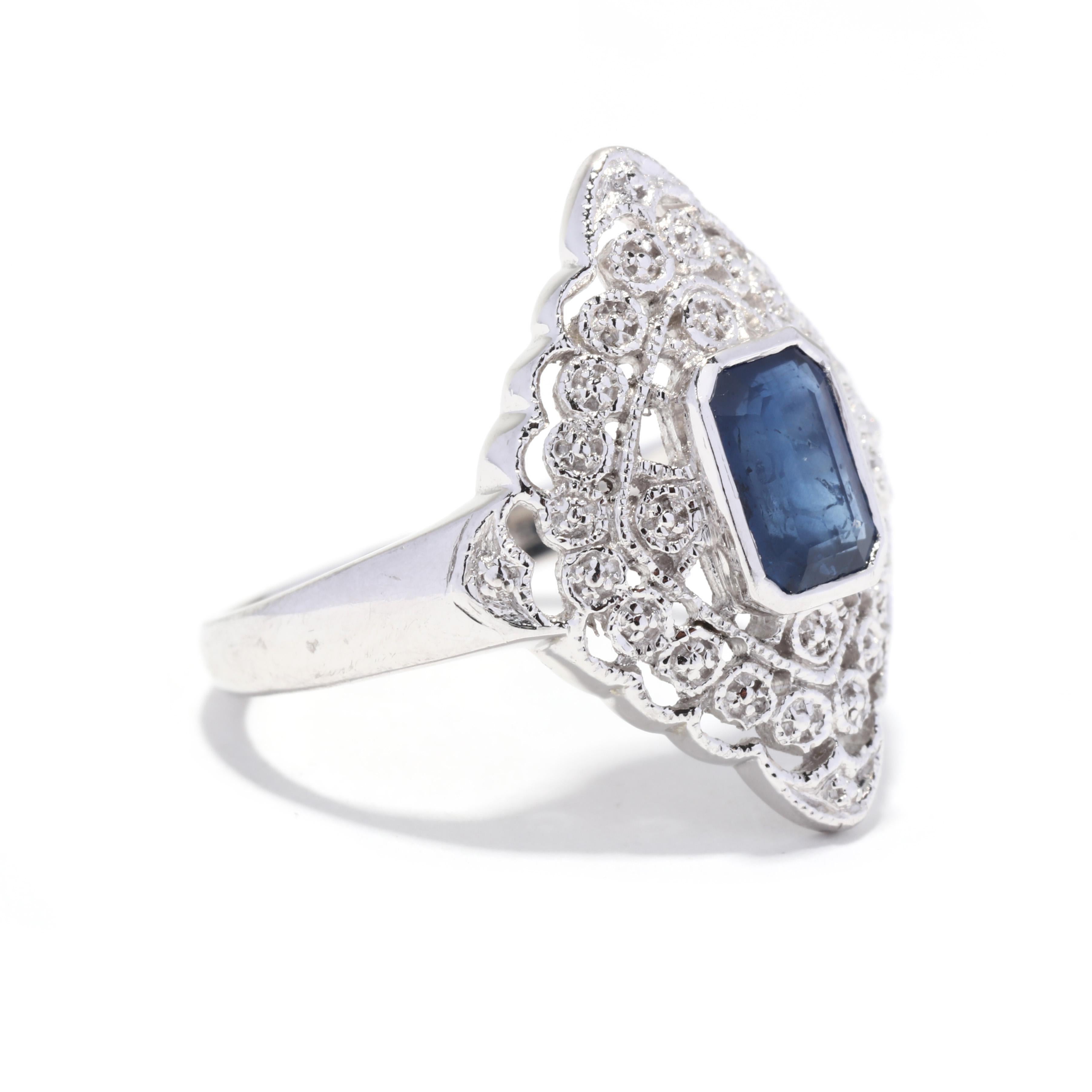 A vintage platinum sapphire navette ring. This large statement ring features a bezel set, emerald cut sapphire weighing approximately 1.30 carat, set in a navette shape ring with engraved, milgrain foliate and scalloped detailing.

Stones:
-