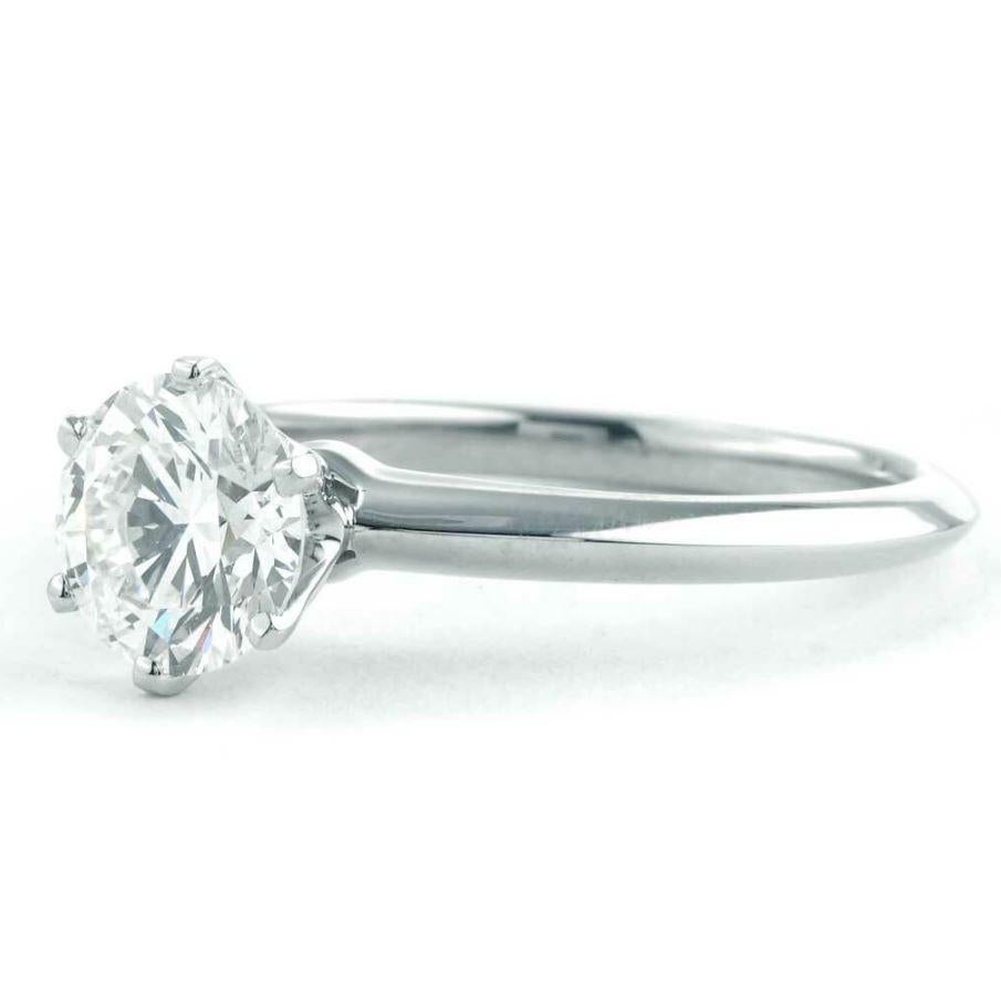 Previously owned Tiffany & Co. Solitaire Collection ring. The ring is a size 6 (US), made of platinum, and weighs 3.0 DWT (approx. 4.67 grams). It also has one round H-color, VS2-clarity diamond weighing 1.30 CT. The center is GIA Certified, and