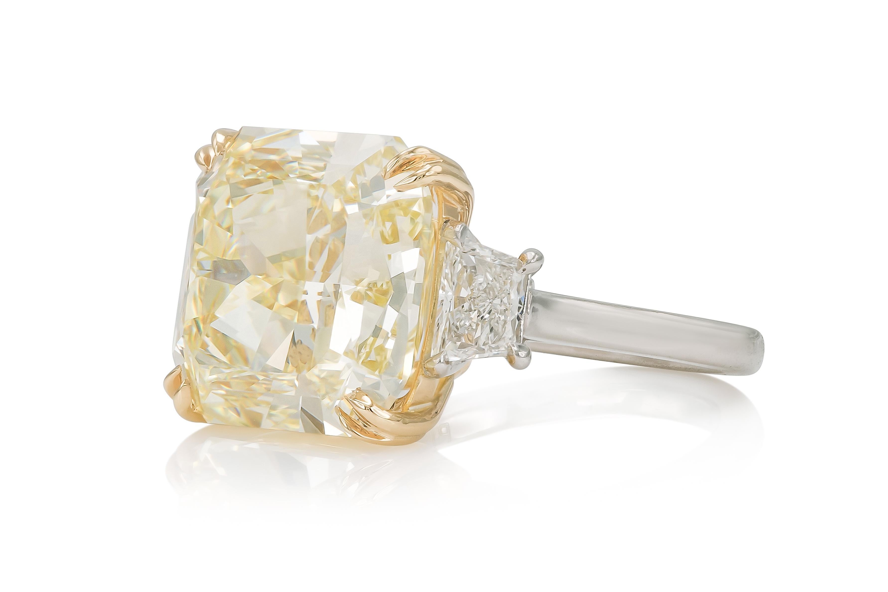 Finement travaillée en platine et or jaune 18 carats avec un diamant carré certifié GIA de taille radiant pesant 13,02 carats, de couleur jaune vif, pureté VVS2, GIA #2231057232.
La bague comporte deux diamants latéraux de taille trapézoïdale pesant