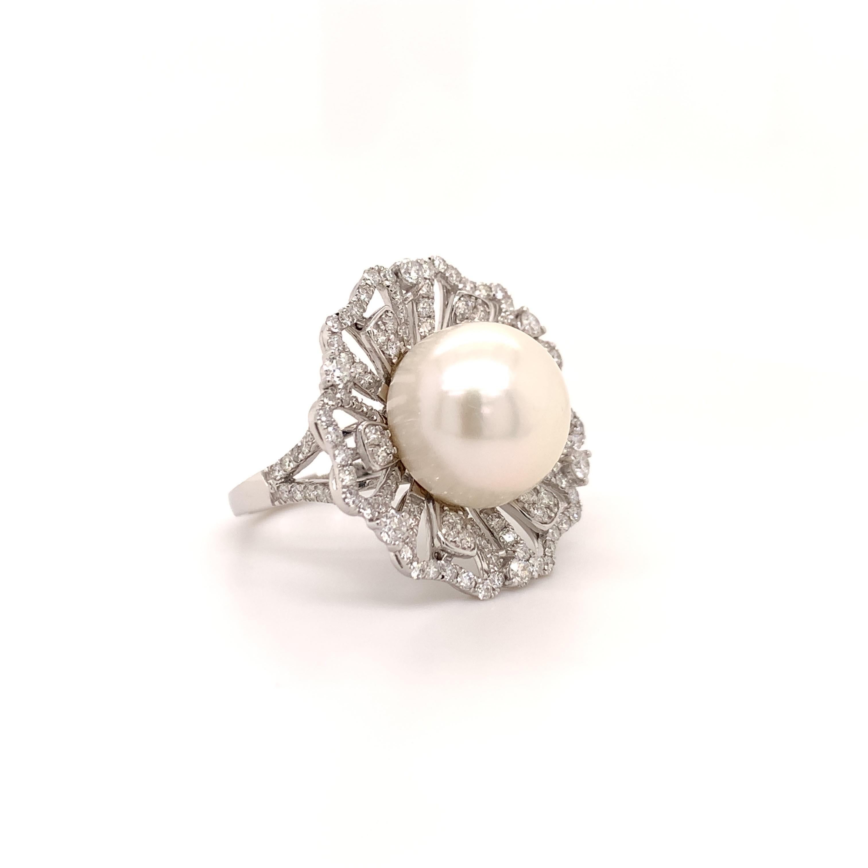 Glamouröser Cocktailring. Hochglänzende, silbrig-weiße, runde 13,02 mm große Südsee-Zuchtperle, gefasst im Hochprofil, akzentuiert im eleganten Blumendesign mit runden Diamanten im Brillantschliff. 
Handgefertigtes Design, gefasst in 14 Karat