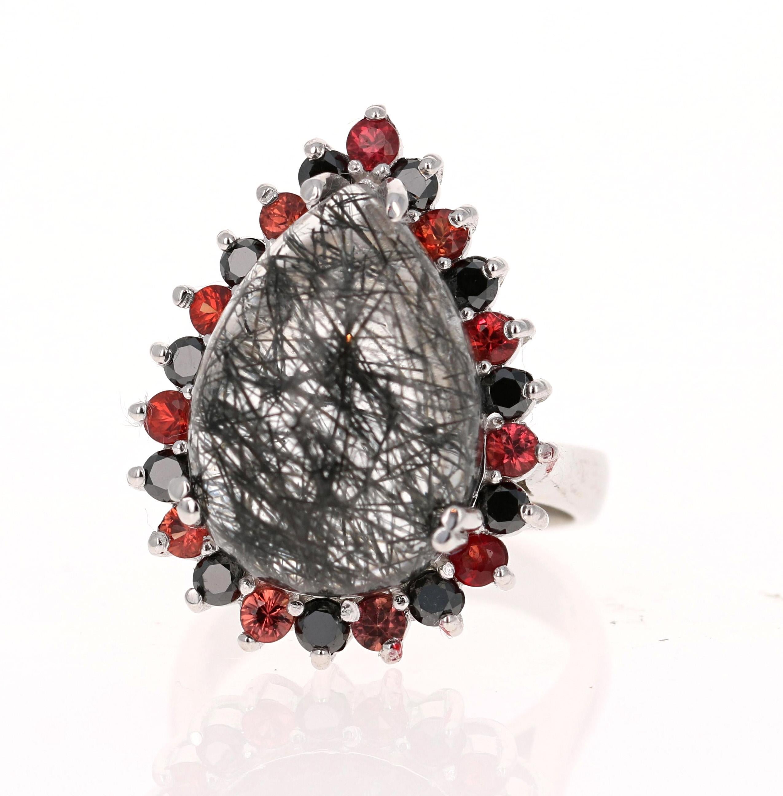 
13.03 Carat Black Diamond, Black Rutilated Quartz and Sapphire White Gold Cocktail Ring  

An 11.44 Carat Pear Cut Black Rutilated Quartz sits in the center of the ring and is surrounded by alternating Black Round Cut Diamonds and Red Round Cut