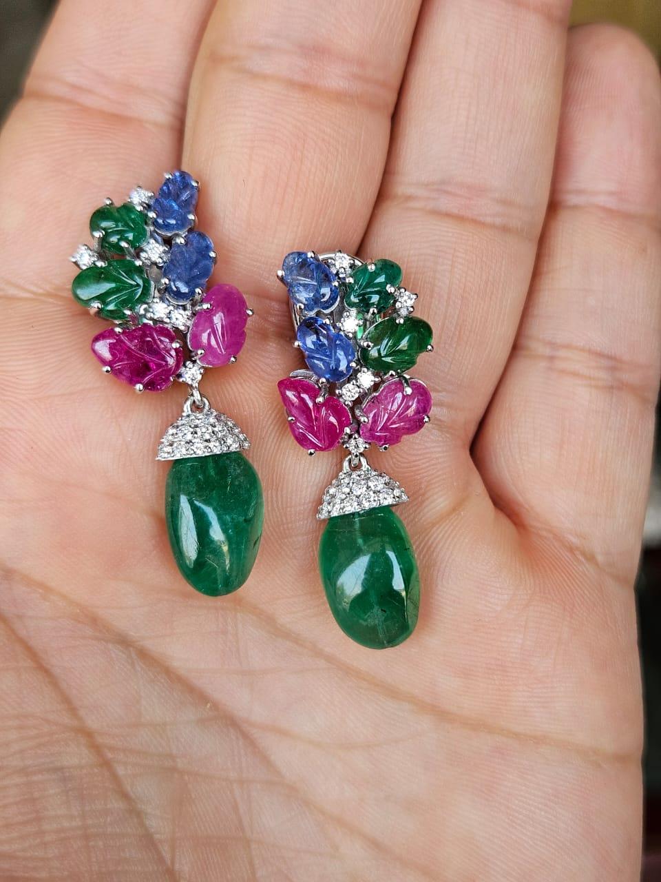 A very gorgeous and beautiful, one of a kind, Emerald, Ruby & Blue Sapphires Chandelier Drop Earrings set in 18K White Gold & natural Diamonds. The weight of the Emerald Tumbles is 13.04 carats. The Emerald tumbles are completely natural, without