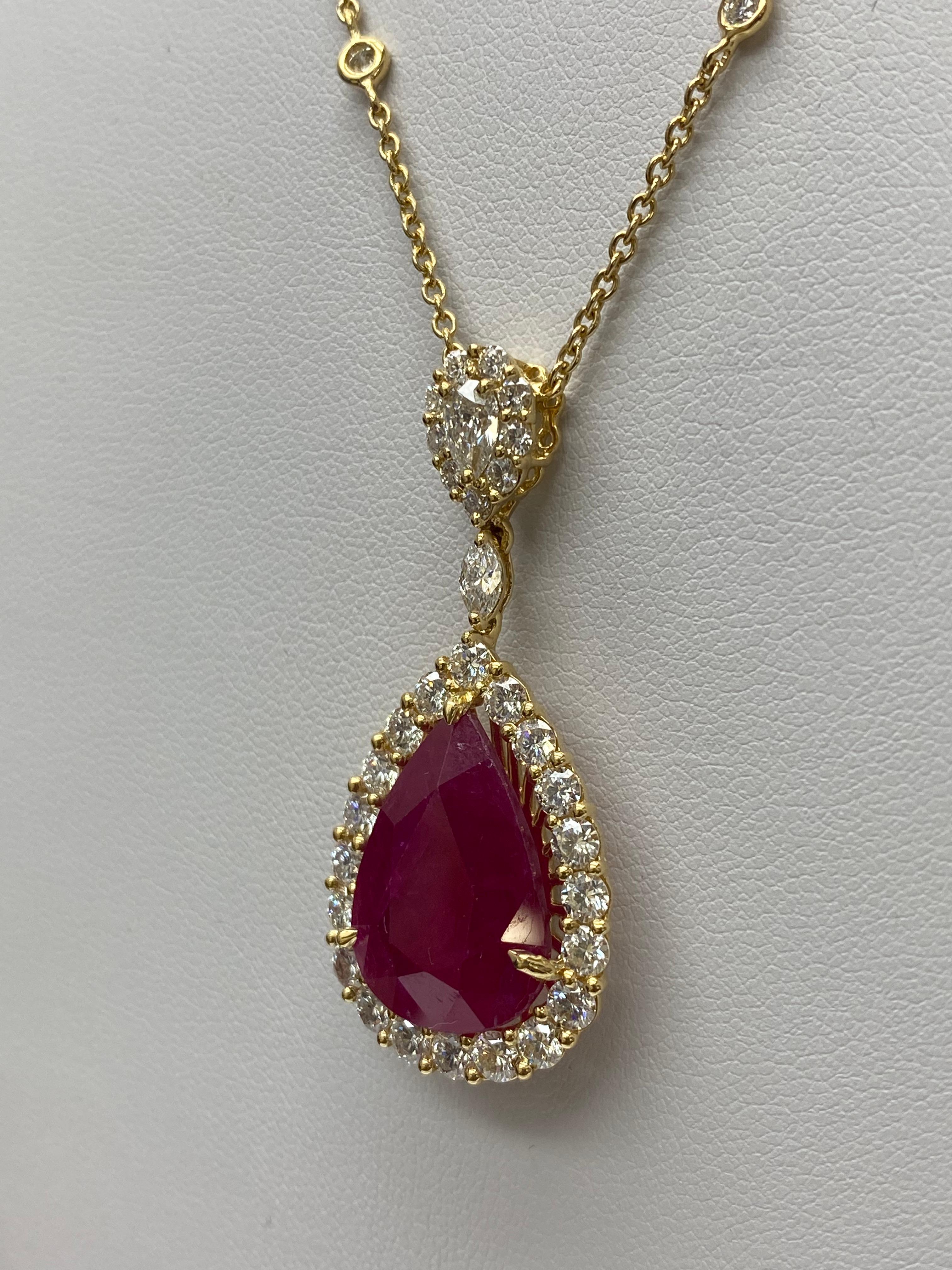 Un collier pendentif classique mettant en valeur un rubis en forme de poire pesant 13.05 carats au total. Elle est ornée d'une rangée de diamants ronds d'un poids total de 2.97 carats. Suspendu à un halo de diamants en forme de poire, attaché à une