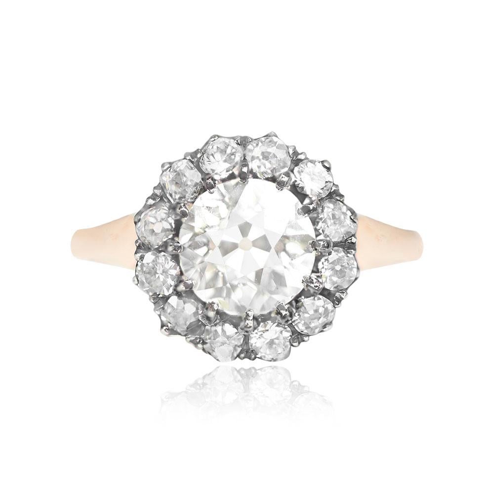 Diamond cluster ring showcasing a prong-set old European cut diamond center weighing 1.30 carats (M color, VS1 clarity). The center stone is encircled by a floral design halo of old European cut diamonds. Handcrafted in silver on 18k yellow gold,