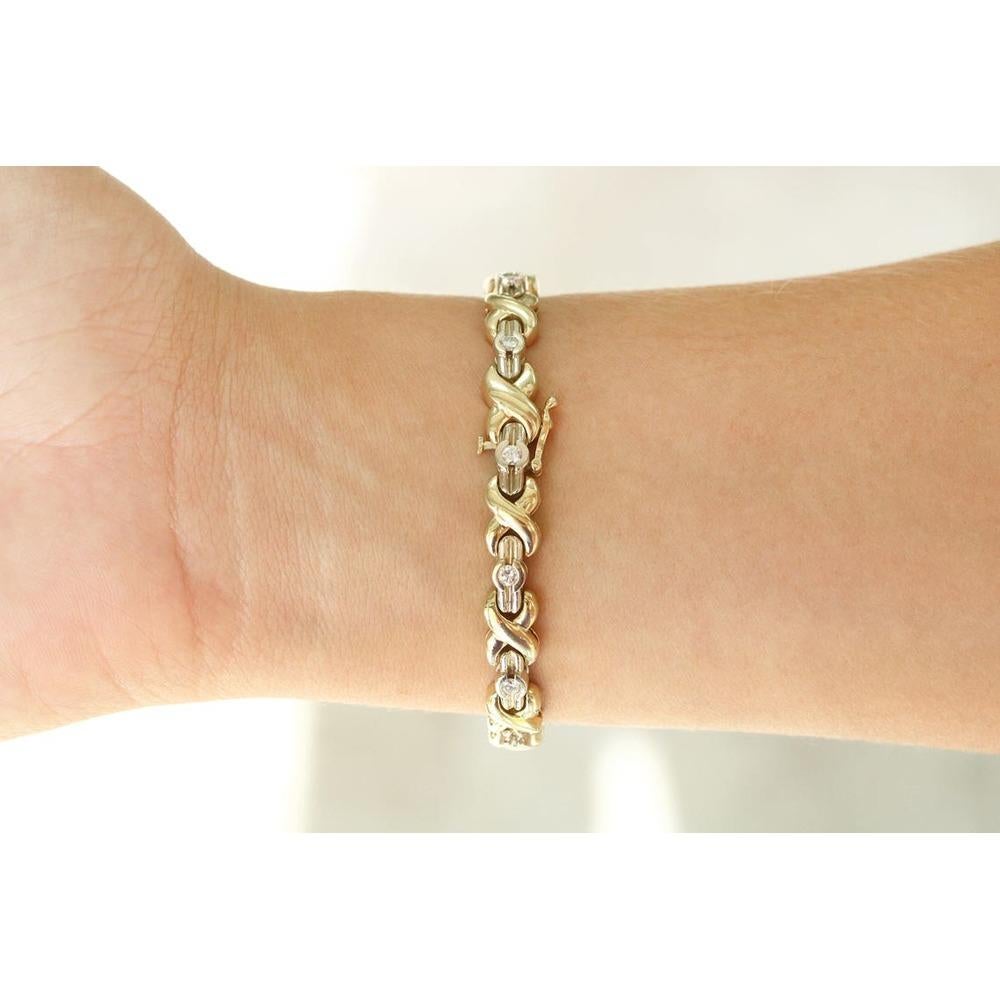 A fancy X & O shaped diamond bracelet in 14K yellow and white gold. This bracelet features a unique golden link embellished by white diamonds. The X's are made in sleek, high-polished yellow gold while the diamonds are set in O shaped bezels.