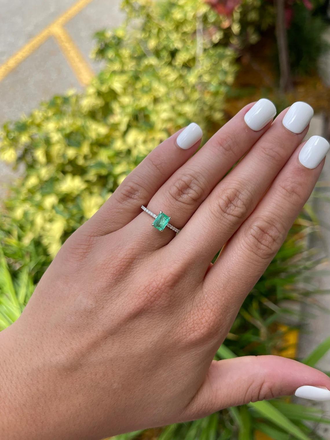 A stunning emerald and diamond engagement ring. The center stone features a beautiful 1.10-carat, natural Colombian emerald-emerald cut. The gem displays a ravishing spring green color, with a yellowish-green hue and very good luster. Natural