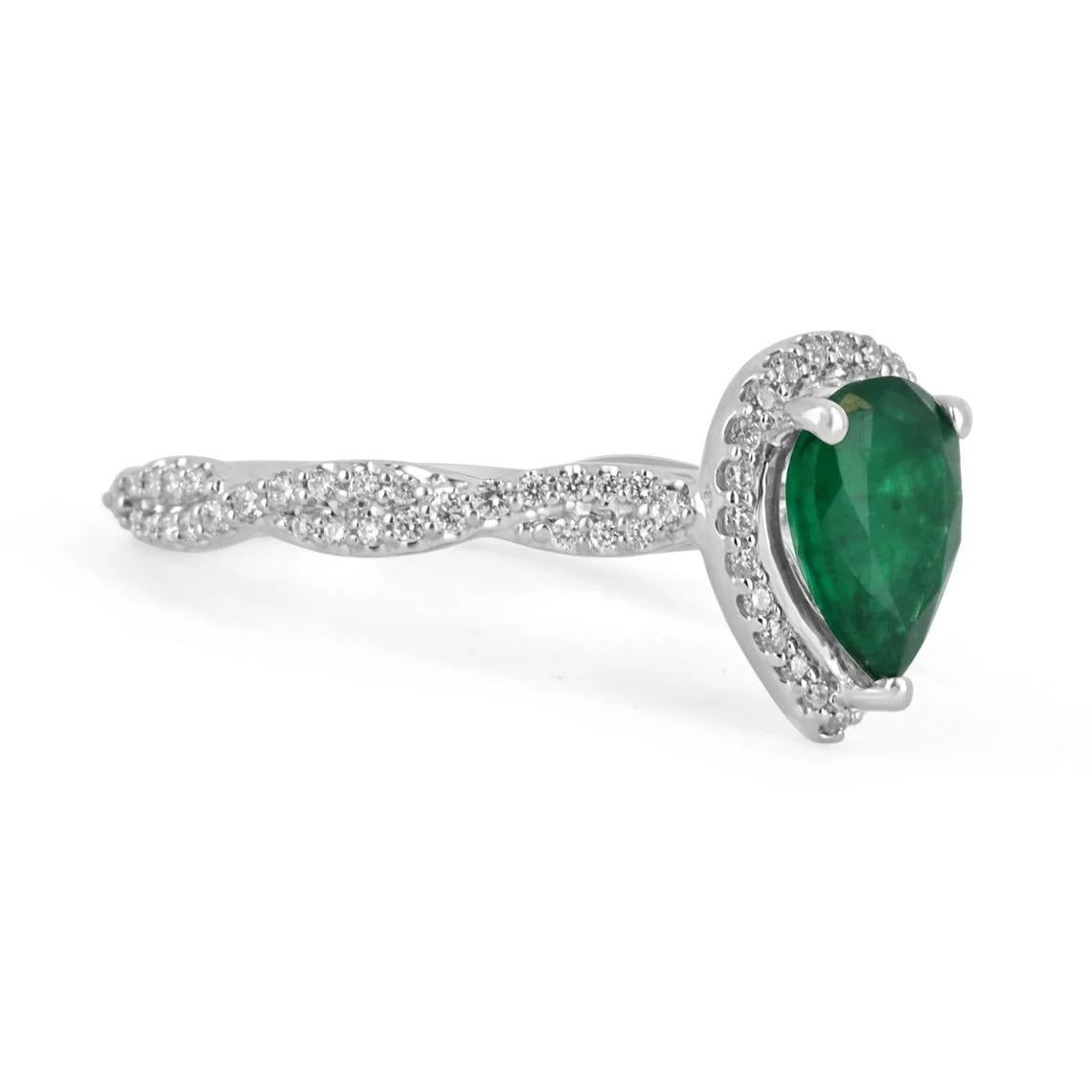 Showcased is a remarkable natural emerald & diamond engagement ring. The center stone displays a stunning, 1.0-carat pear cut Brazilian emerald with excellent qualities. A desirable dark green color, and very good luster. Surrounding this precious