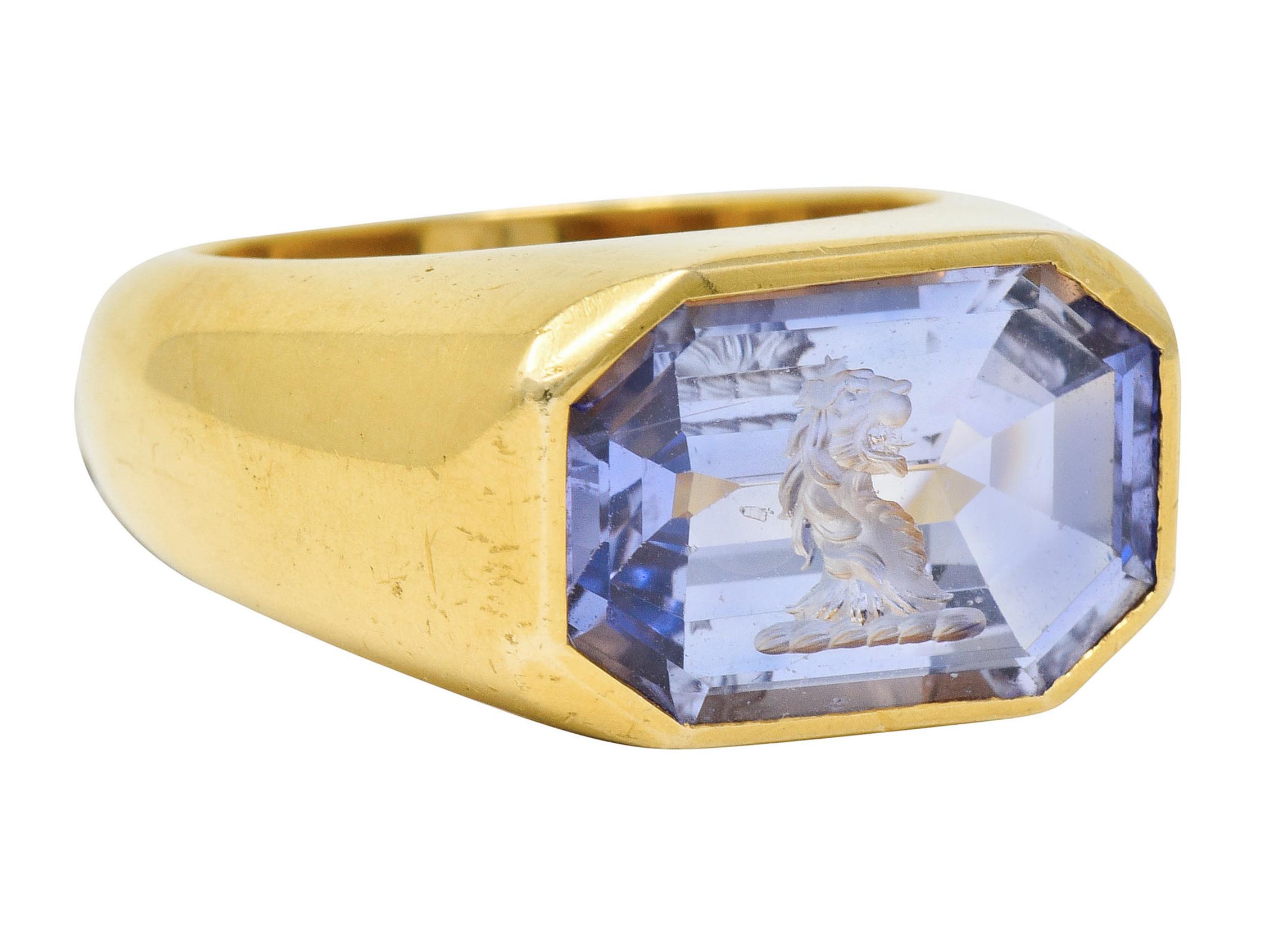 Centering an octagonal cut sapphire weighing approximately 13.10 carats

Exhibiting color-change with bluish-violet color in fluorescent light and purple under incandescent light

Bezel set and deeply carved to depict a roaring lion

Tested as 22