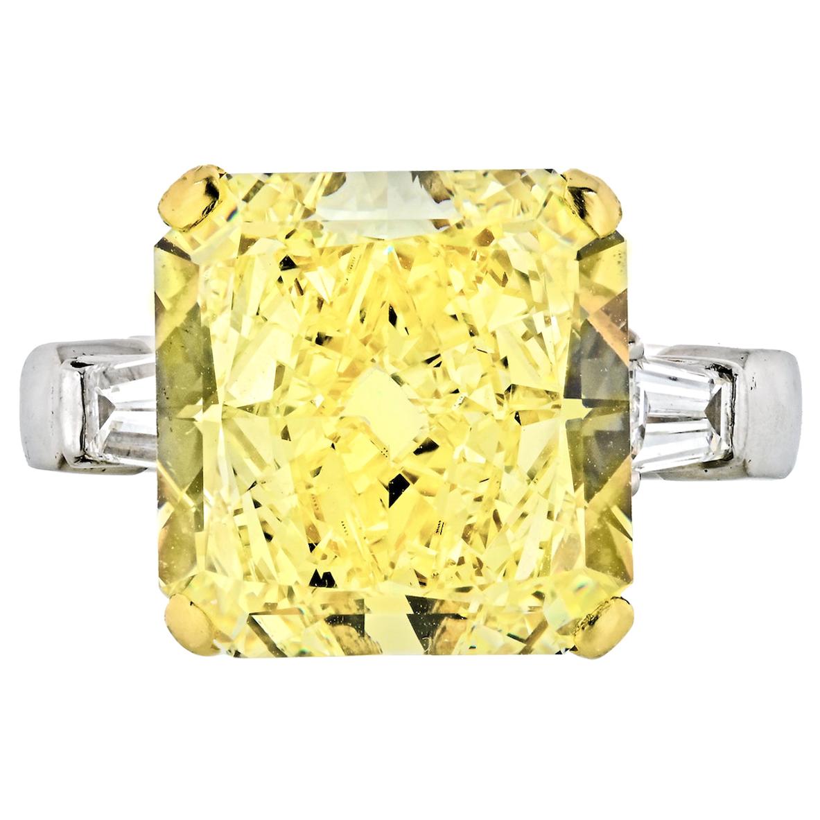 Important GIA Certified Graff 13.11 Carat Radiant Cut Natural Fancy Yellow Diamond, Platinum, and 18 Karat Yellow Gold Engagement Ring. Accented with two bullet shape diamonds approx. .30 each. 
Yellow diamond VS2 clarity. Fully inscribed to the