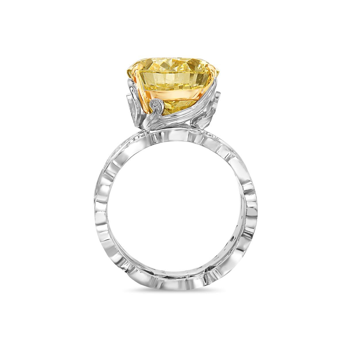 This engagement ring features a 13.11 carat fancy yellow VVS2 oval diamond set in a platinum and 18K yellow gold barouque style setting with matching band. GIA Certified. Report No. 5191115266. Size 8. 

Resizeable upon request.

Viewings available