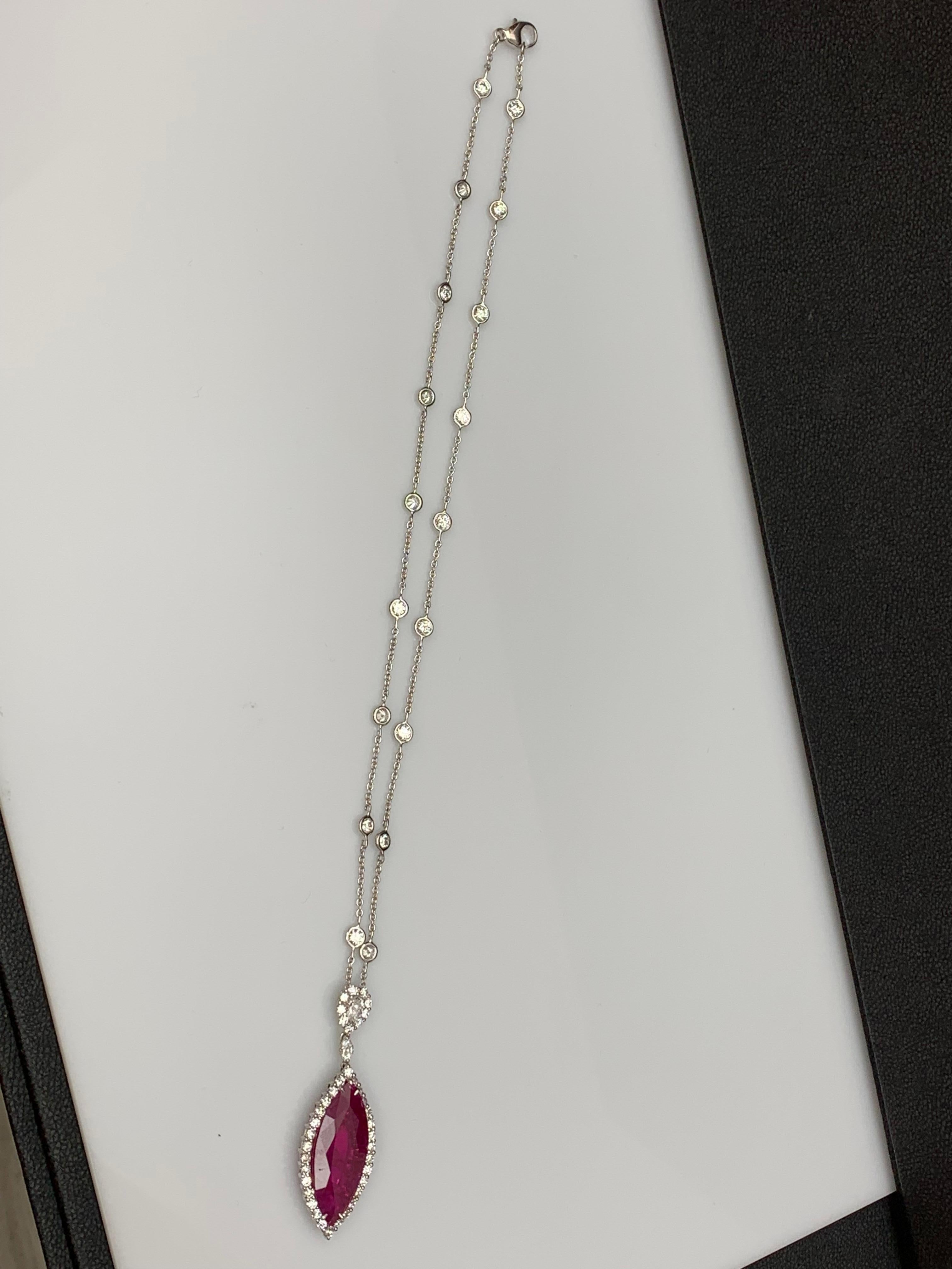 Showcasing a Marquise shape Vibrant Ruby weighing 13.15 carats. Surrounded by a row of brilliant round diamonds. Pendant suspended on an pear shape diamond halo, attached to a diamond by the yard chain made in 18 karats white gold. Pear and Marquise
