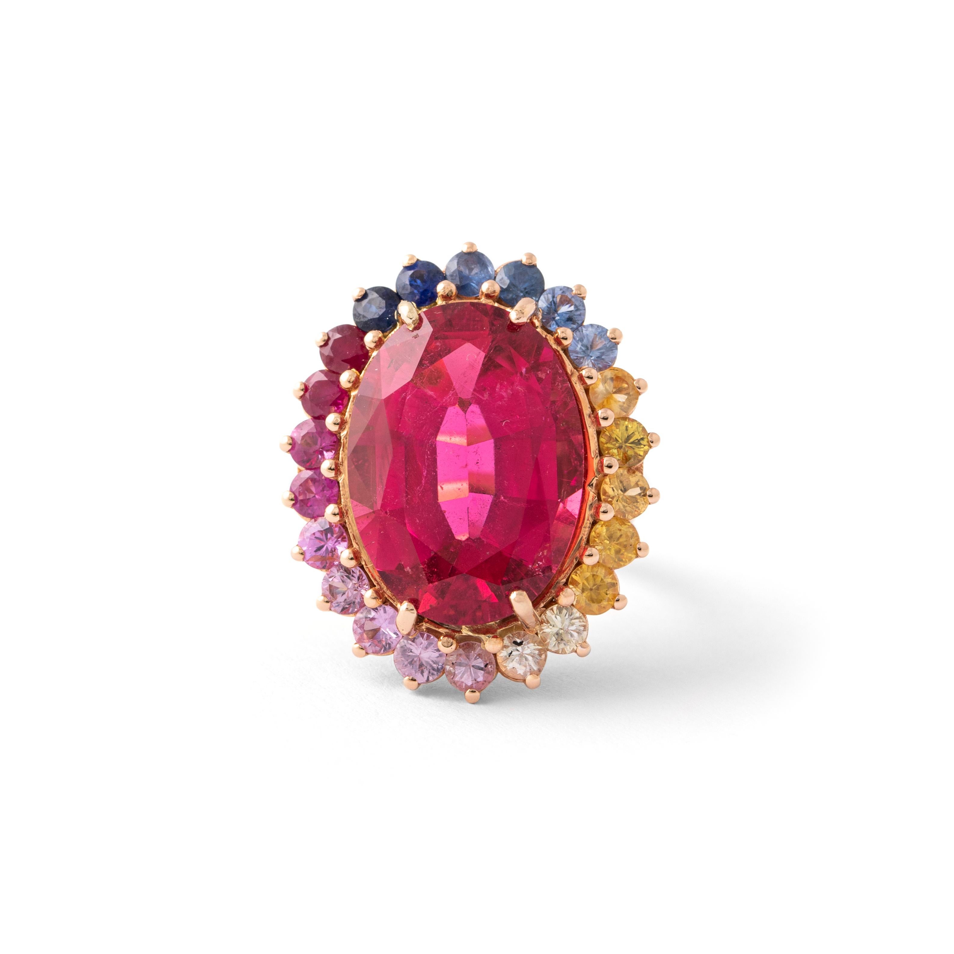 Anello da 13,15 carati con tormalina rosa (rubellite) circondata da zaffiri colorati in oro rosa 18 carati. 

Dimensioni: circa 2,60 cm x 2,20 cm.
Peso totale: 14,09 grammi.

Misura dell'anello: 53 / 6,5 US.

