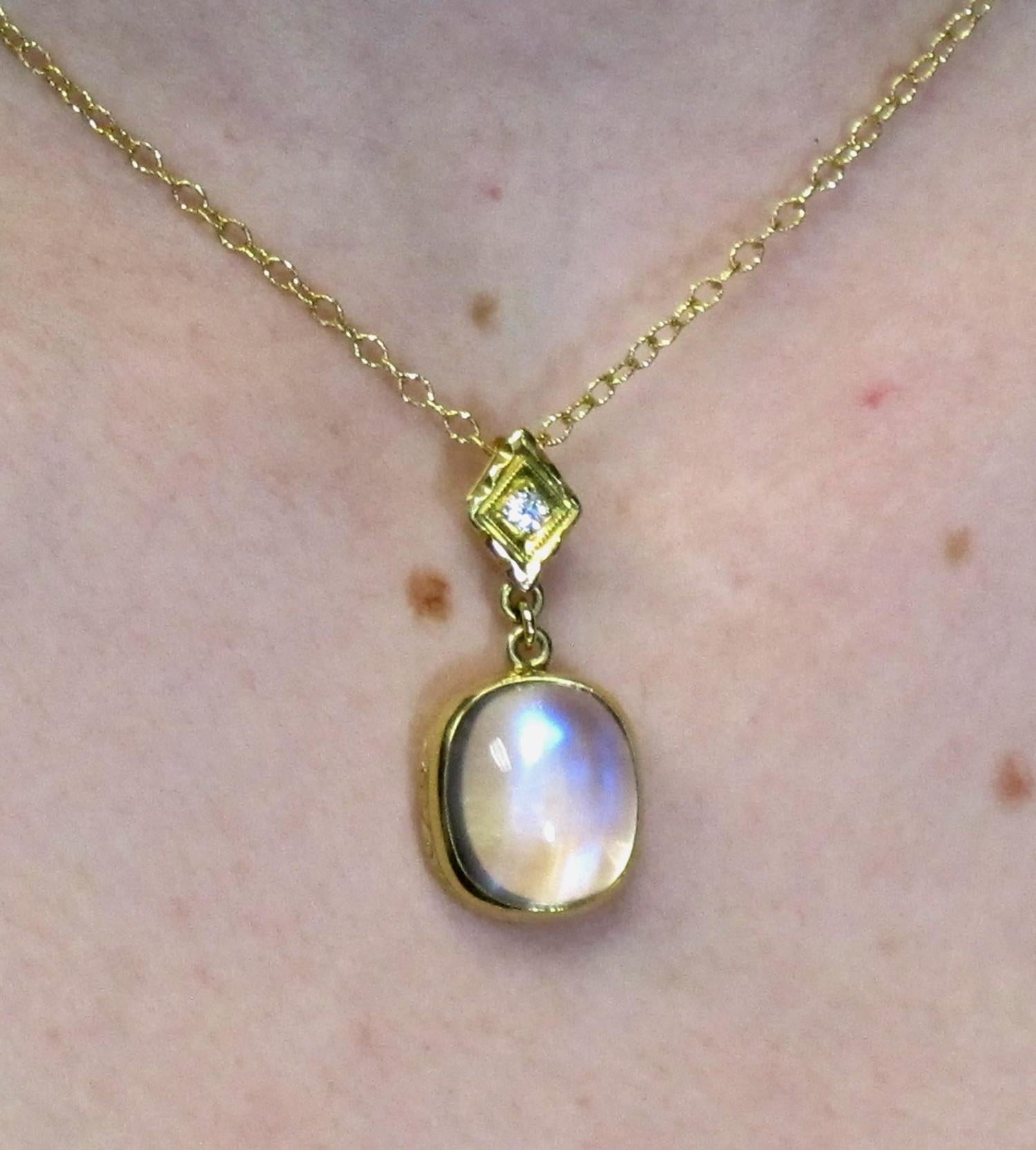 This handmade pendant features a beautiful  cushion cut  Rainbow Moonstone 14.30x12.20mm (13.15cts) with 1 round brilliant cut diamond (0.05cts). The  moonstone has a beautiful, billowing light effect, giving it a mysterious glow.  Worn on an 18k