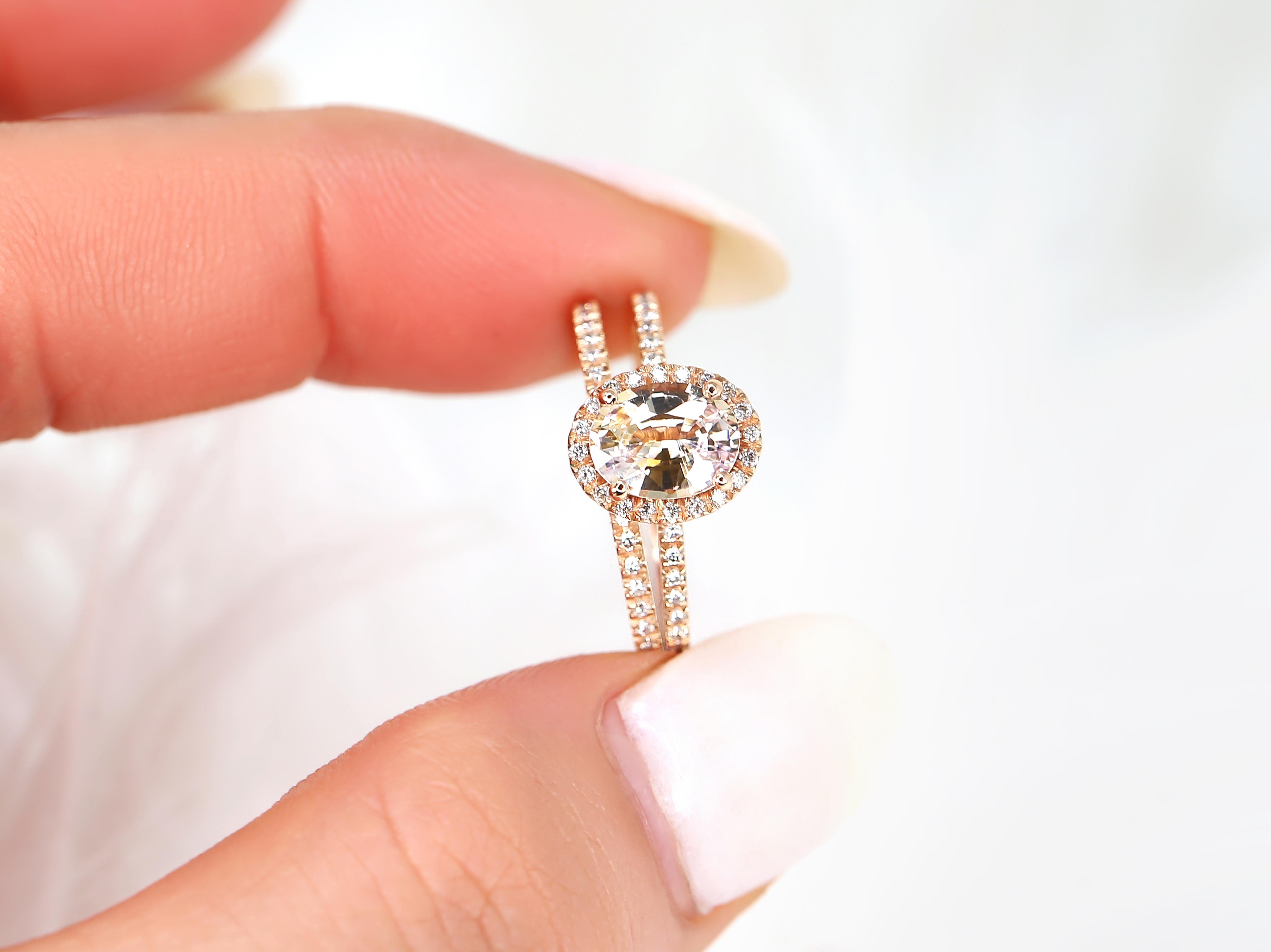 Rayonnez d'élégance et de romantisme avec notre parure nuptiale ovale en saphir pêche champagne. La pierre centrale, de forme ovale, est entourée d'un halo de diamants et complétée par des diamants pavés classiques.

Détail de l'anneau (des anneaux)