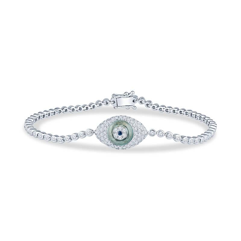 This evil eye bracelet features 1.31ct total weight in round brilliant cut bezel set diamonds and 0.01 carats in round blue sapphire representing the eye all set in 18 karat white gold. Box clasp with double safety clasp. The length is 6.5