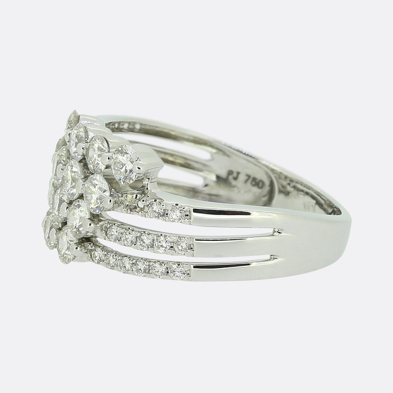 Here we have an 18ct white gold diamond cluster ring. The shank splits into four rows; each of which plays host to 4 sizeable round brilliant cut diamonds that a flanked on either split shoulder by three rows of matching smaller stones. 

Condition: