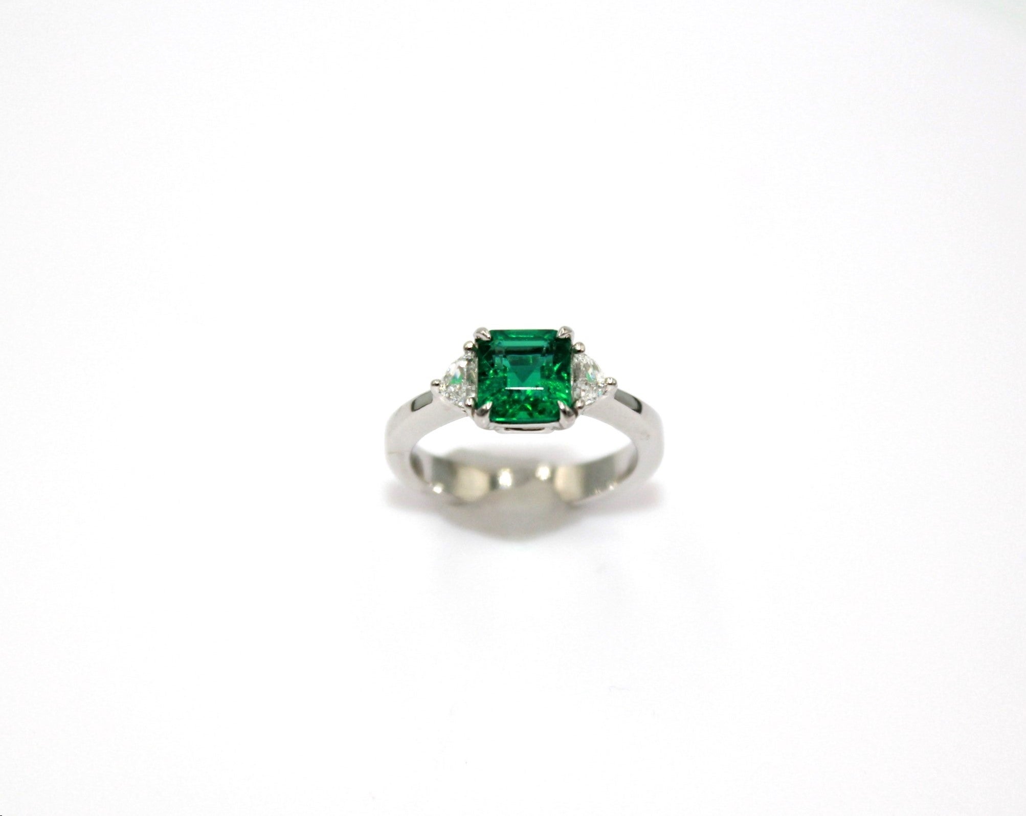 Three-stone ring with 1.32 carats Emerald-cut Zambian Emerald with paired Cadillac shape diamonds on both sides, totaling a diamond weight of 0.25 carat. 

This stunning Emerald Diamond Ring will highlight your elegance and uniqueness. 

Item