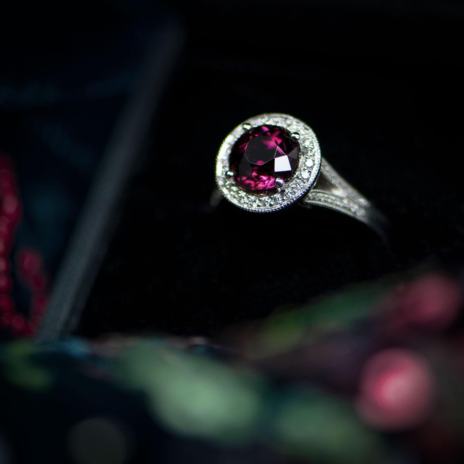 This elegant, ready-to-wear vintage-style ring features a rare and sumptuous Rubellite Tourmaline in a highly sought after, deep purple-red colour. Surrounding the stone is a ring of sparkling diamonds in an elegant  platinum milgrain cluster