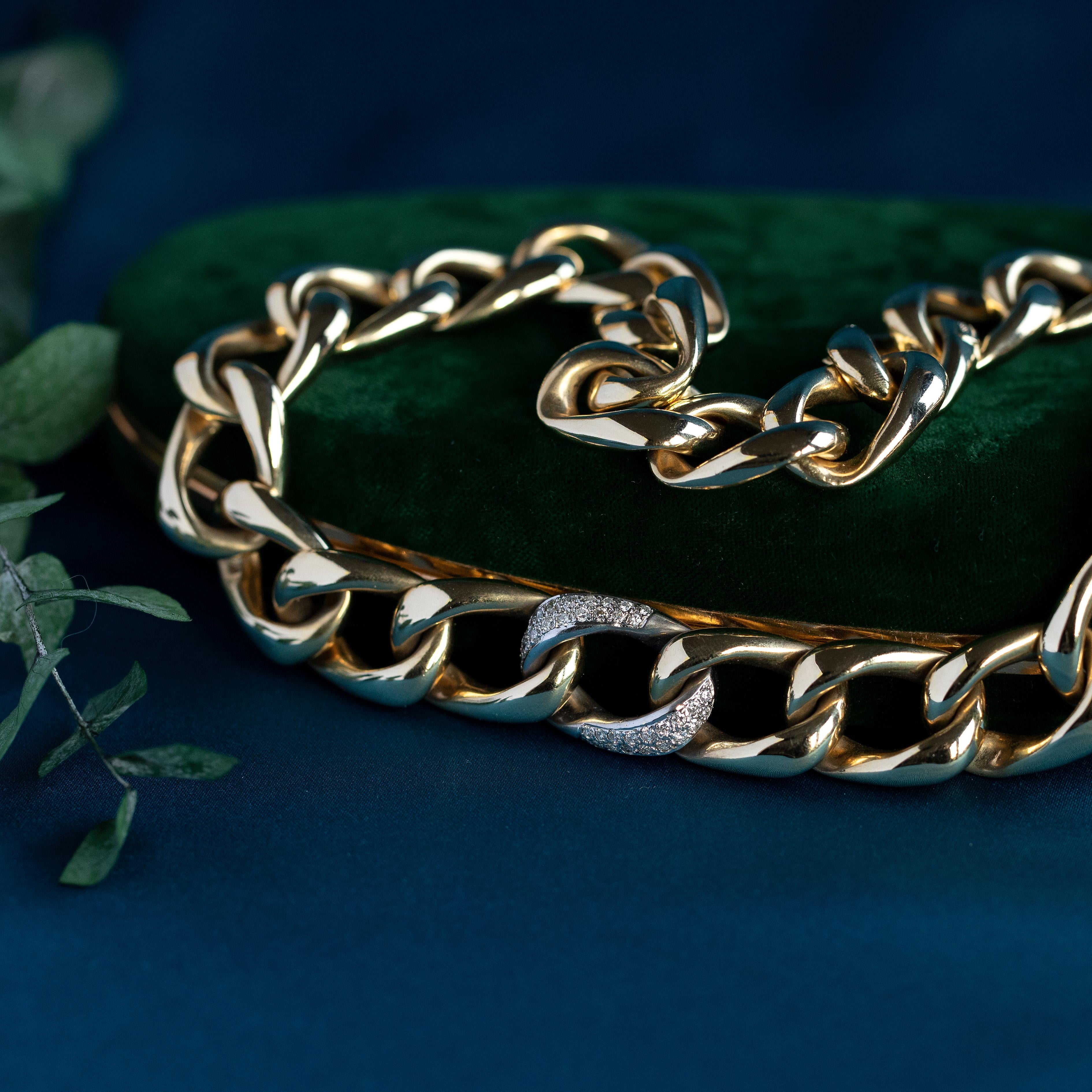 This glamorous chain has been masterfully crafted by hand for a lifetime of enjoyment. Solid statement curb chain links have been formed from buttery solid yellow gold, accented with a singular white gold curb link, centrally set and adorned with