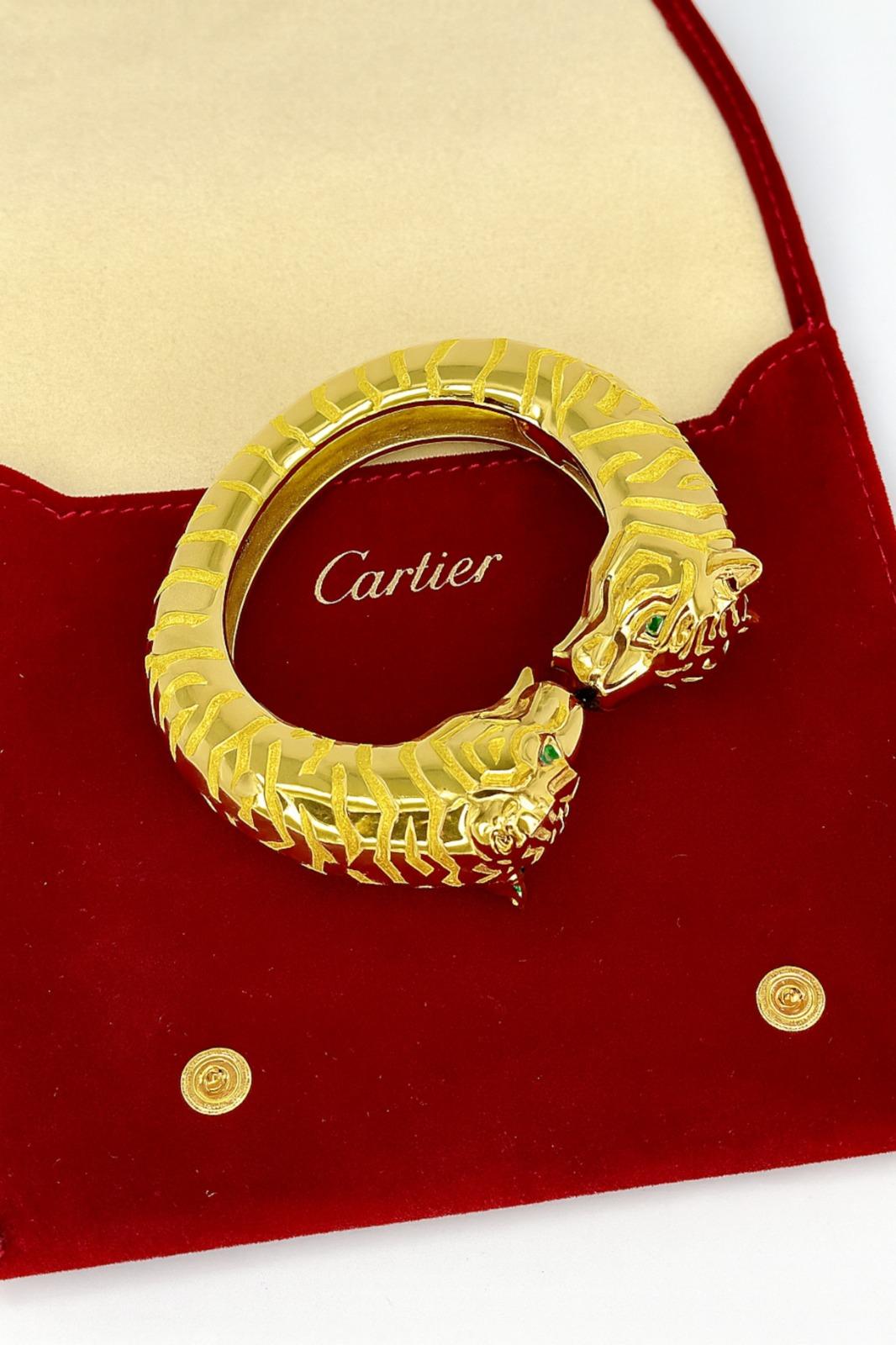 Taglio smeraldo 132 grammi Cartier Bangle a doppia testa di pantera in oro giallo 18 carati con occhi di smeraldo in vendita