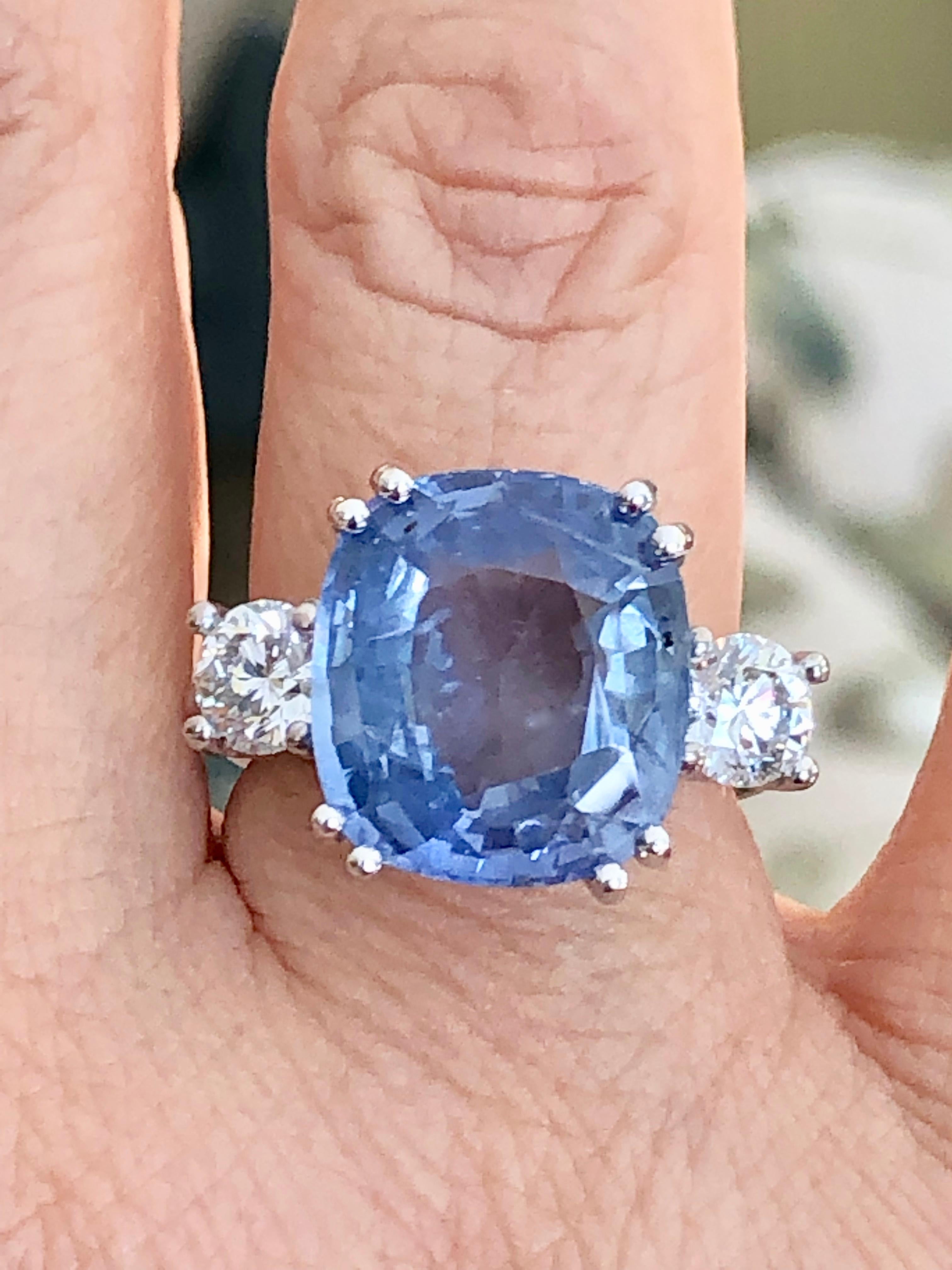 Spectacular 18K white gold sapphire and diamond engagement ring containing 1 cushion cut natural Ceylon blue sapphire with no heat treatment weighing 11.89 carats and 2 brilliant cut diamonds weighing 1.20 carats
Measurements sapphire are 14.13 x