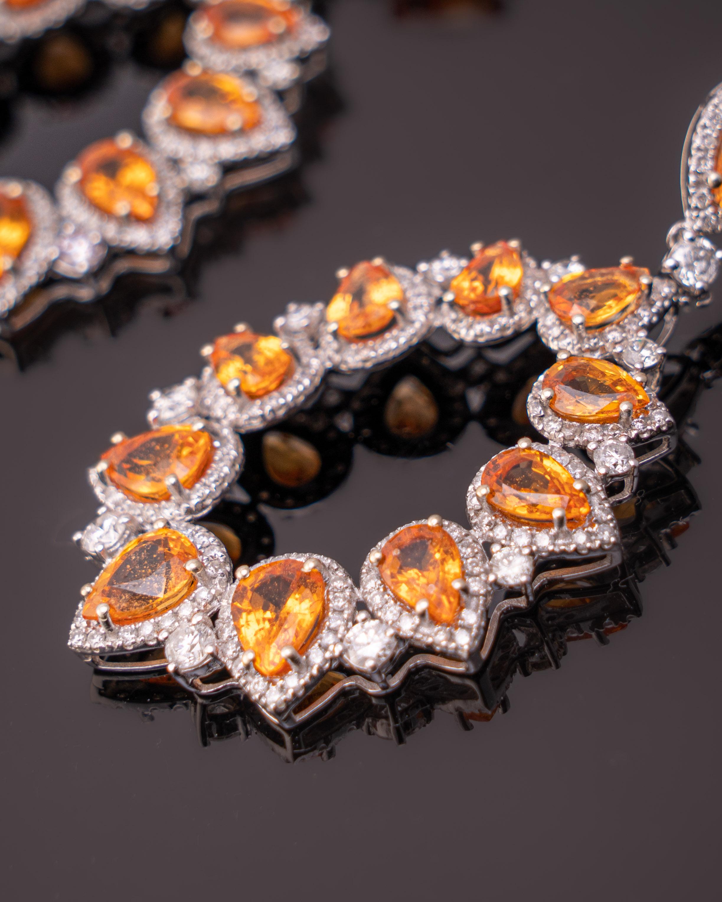Superbes boucles d'oreilles pendantes composées d'un saphir orange en forme de poire de 13,27 carats et d'un diamant blanc de 2,21 carats, le tout monté sur 12 grammes d'or blanc 18 carats. Les saphirs orange sont transparents, ont une couleur très