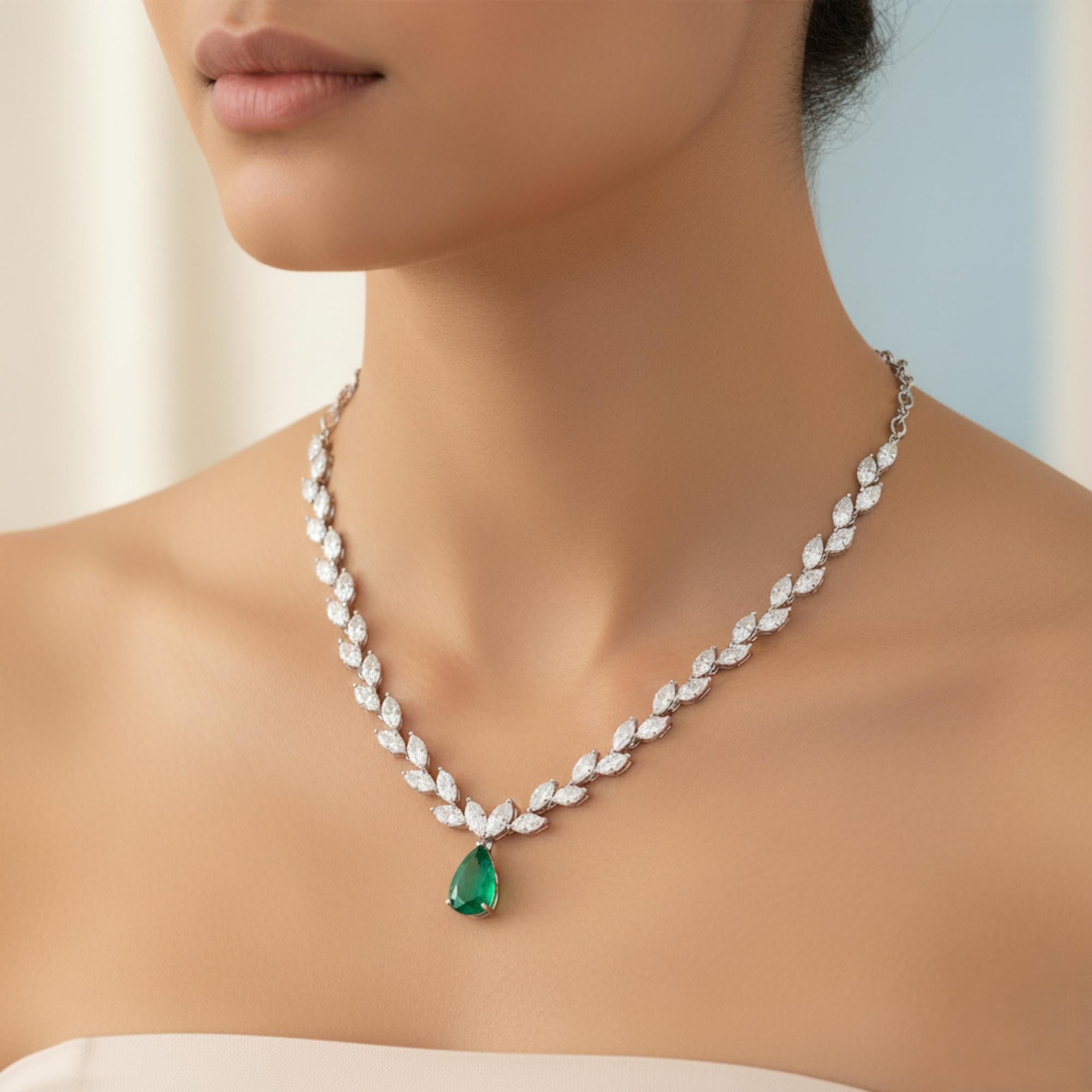 13.2Ct Diamond 2.9Ct Zambian Emerald 14 Karat White Gold Drop Necklace 
The main body of the necklace features a prominent foliate mimicking delicate leaves descending from the chain to meet a striking centerpiece. The upper portion of the chain