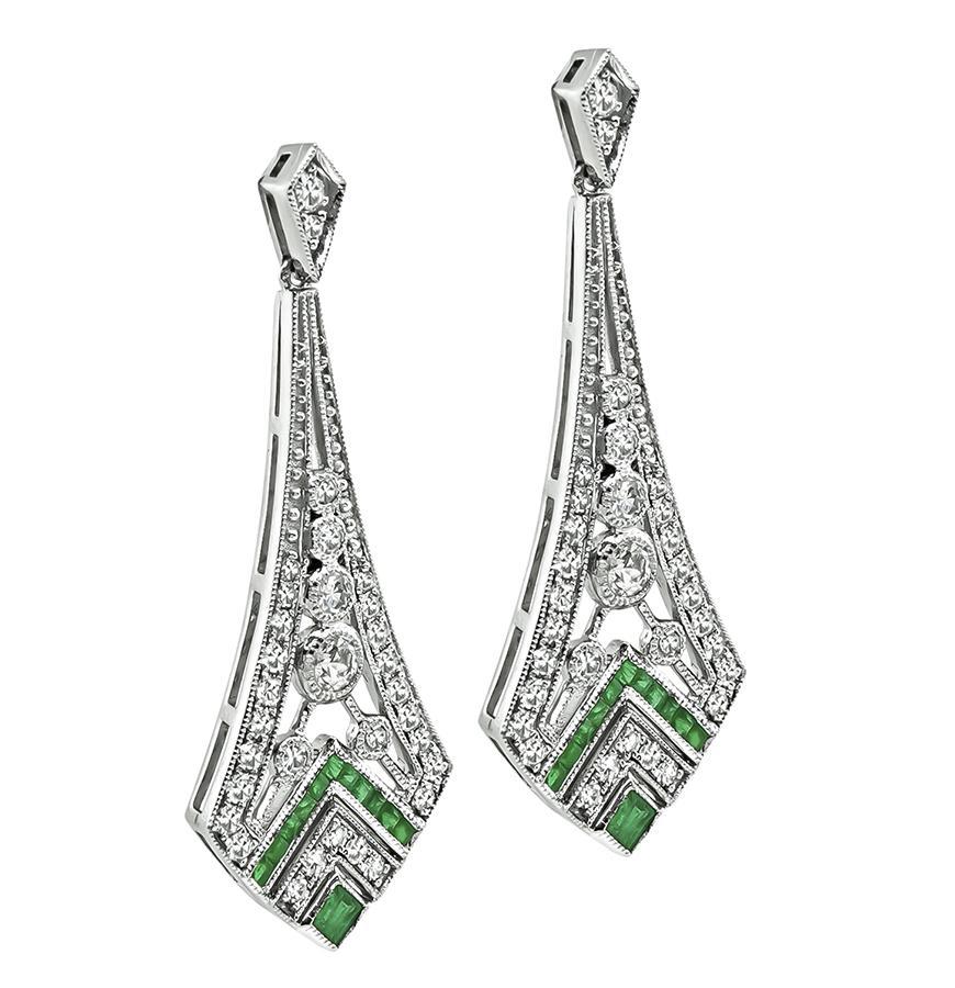 This is a charming pair of platinum earrings. The earrings feature sparkling round cut diamonds that weigh approximately 1.32ct. The color of these diamonds is G-H with VS clarity. The diamonds are accentuated by lovely emerald accents. The earrings